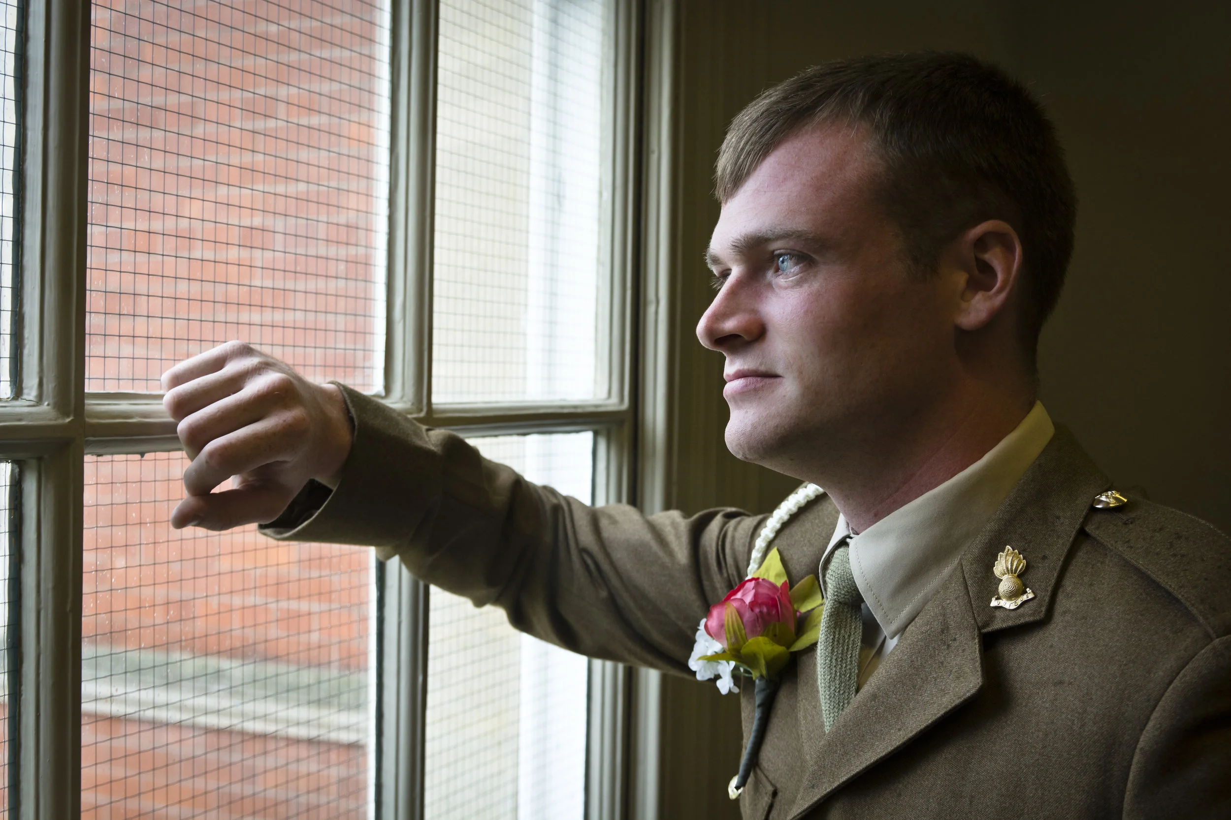 wedding groom looking out window