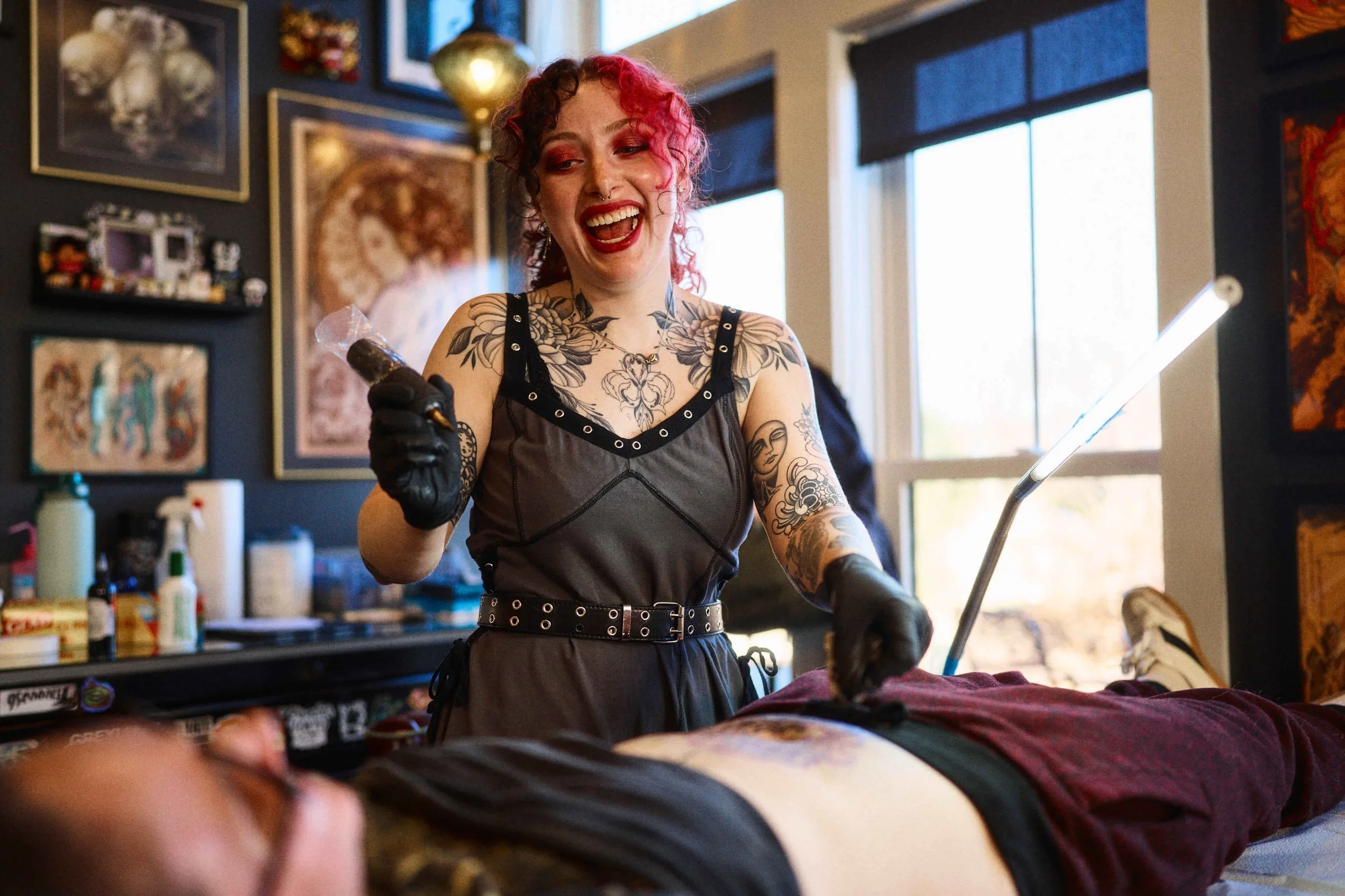 Jasmine Jade tattooing an illustrative black and grey tattoo at Safe House Tattoo Studio in Nashville, Tennessee.