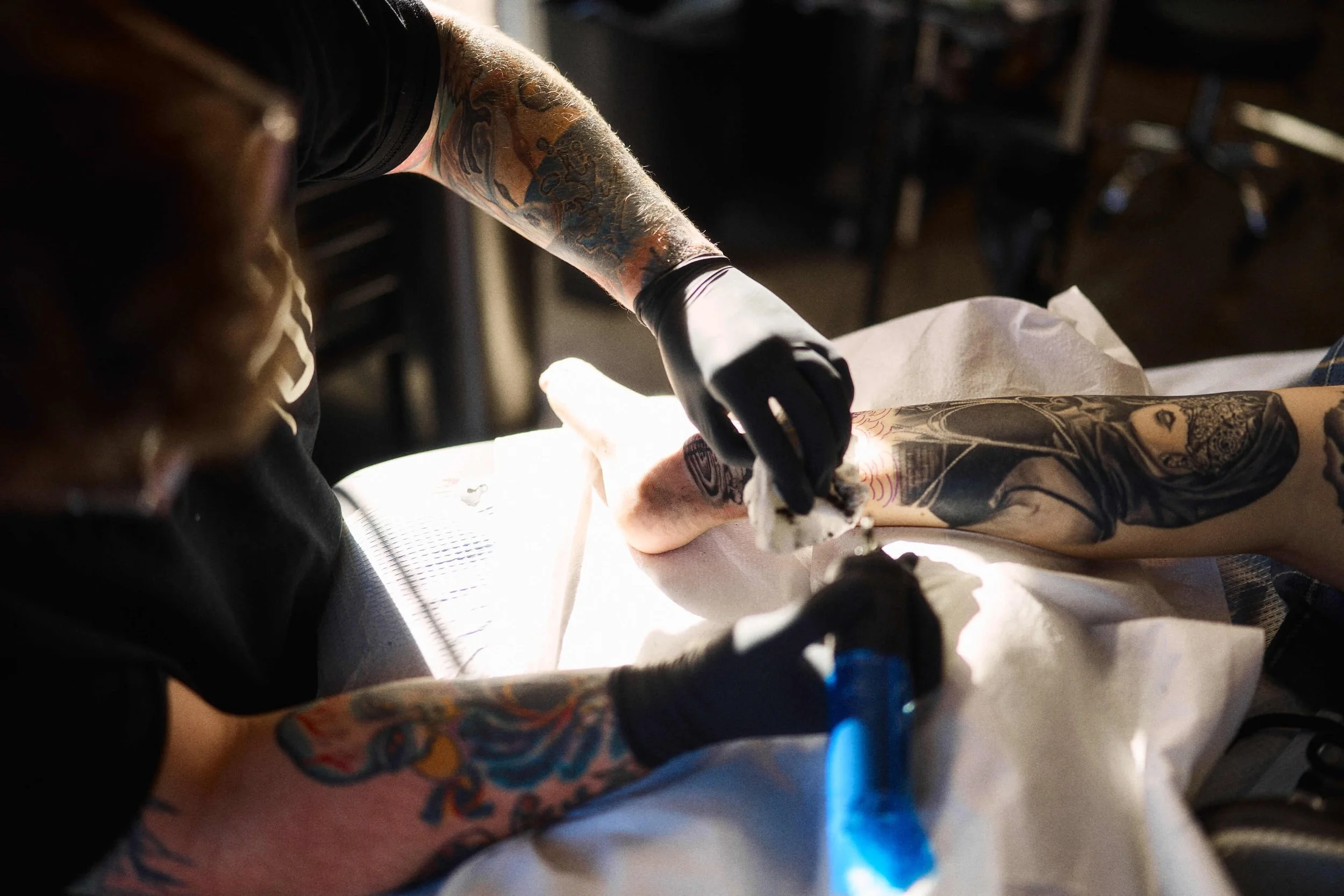 Tattoo artist at Safe House Tattoo working on a custom tattoo