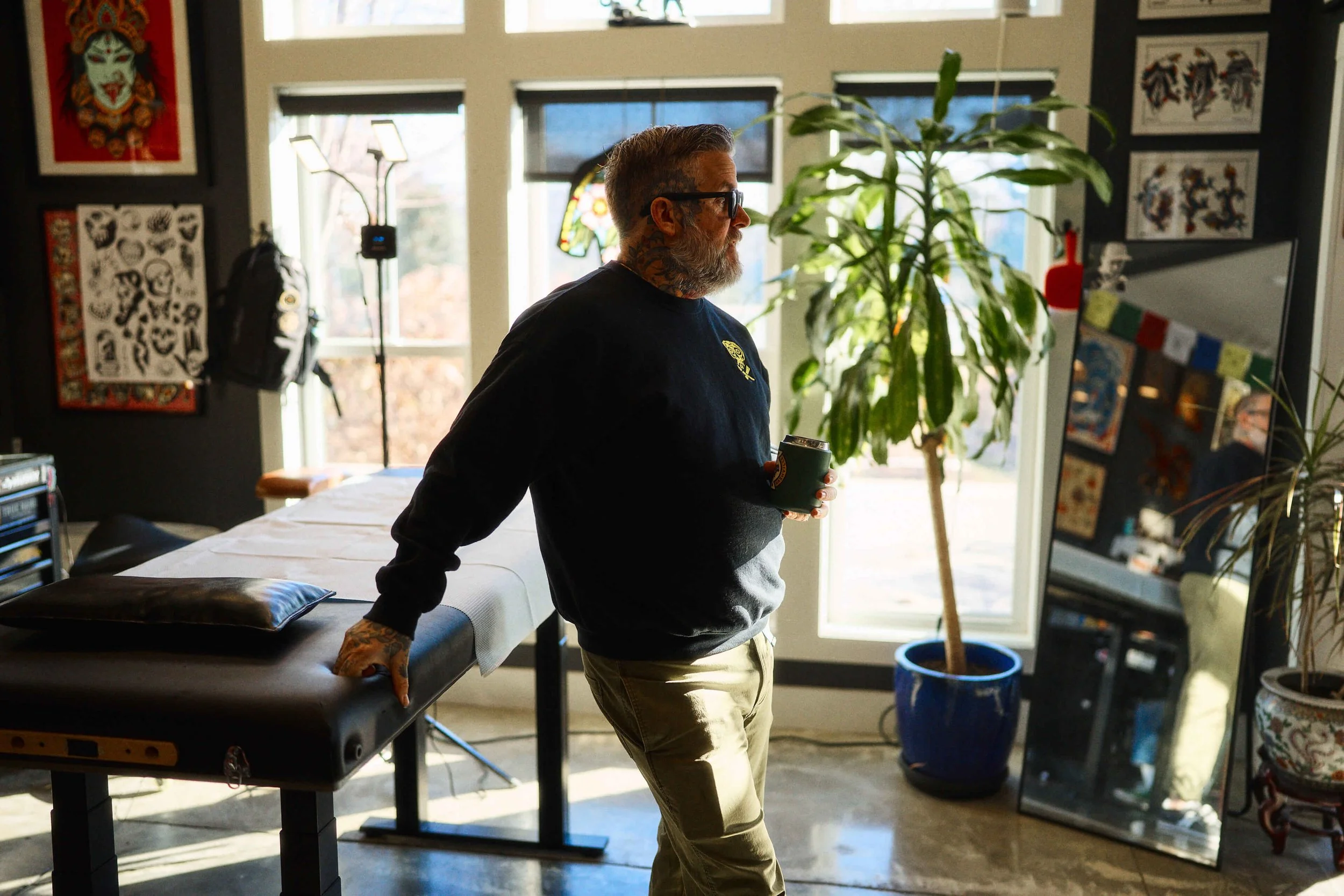Safe House Tattoo owner Ian White standing in his tattoo station at the studio