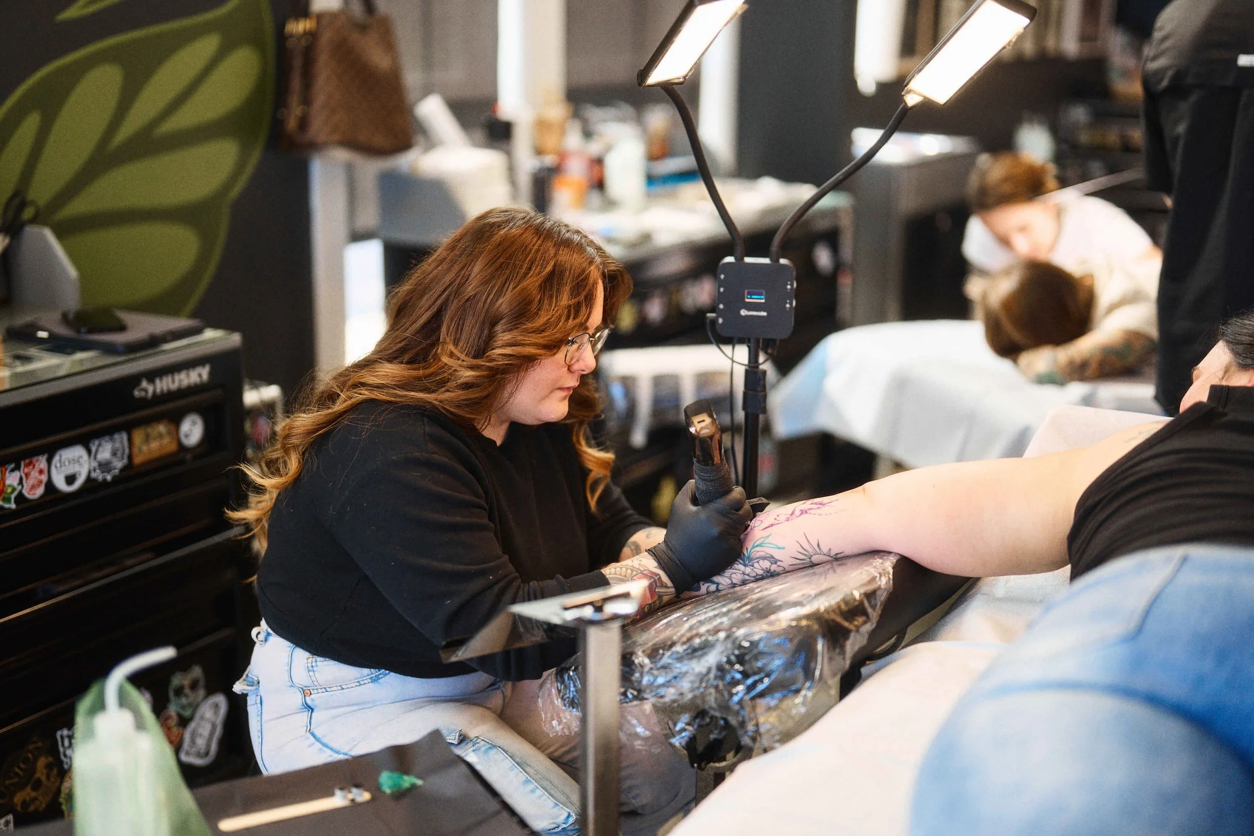 Kim Goff tattooing a color tattoo on a client at Safe House Tattoo Studio in Nashville, Tennessee.