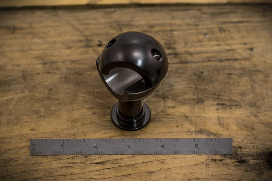 A spherical steel part with intersecting angled bores