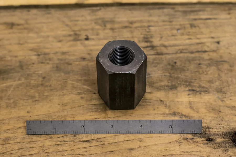 A section of hex bar, bored and threaded