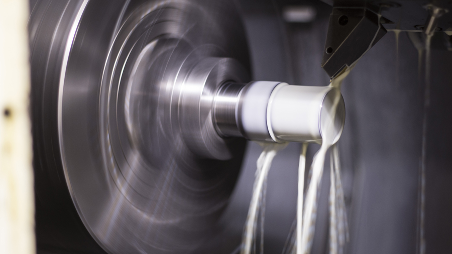 A part turning under coolant at Emig Machine & Tool