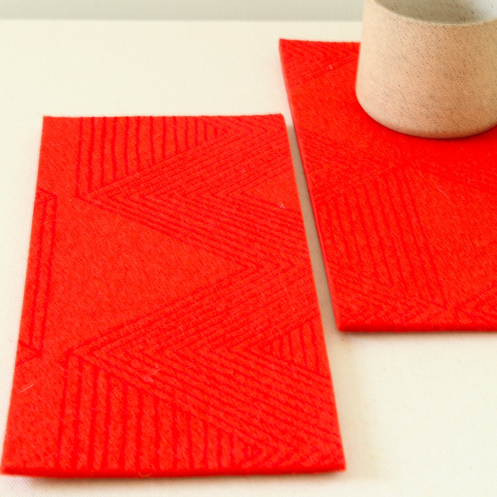 red zig zag printed on tomato organic 100% merino wool felt double coasters 5mm thick and 5" x 10", can be used also as a trivet.