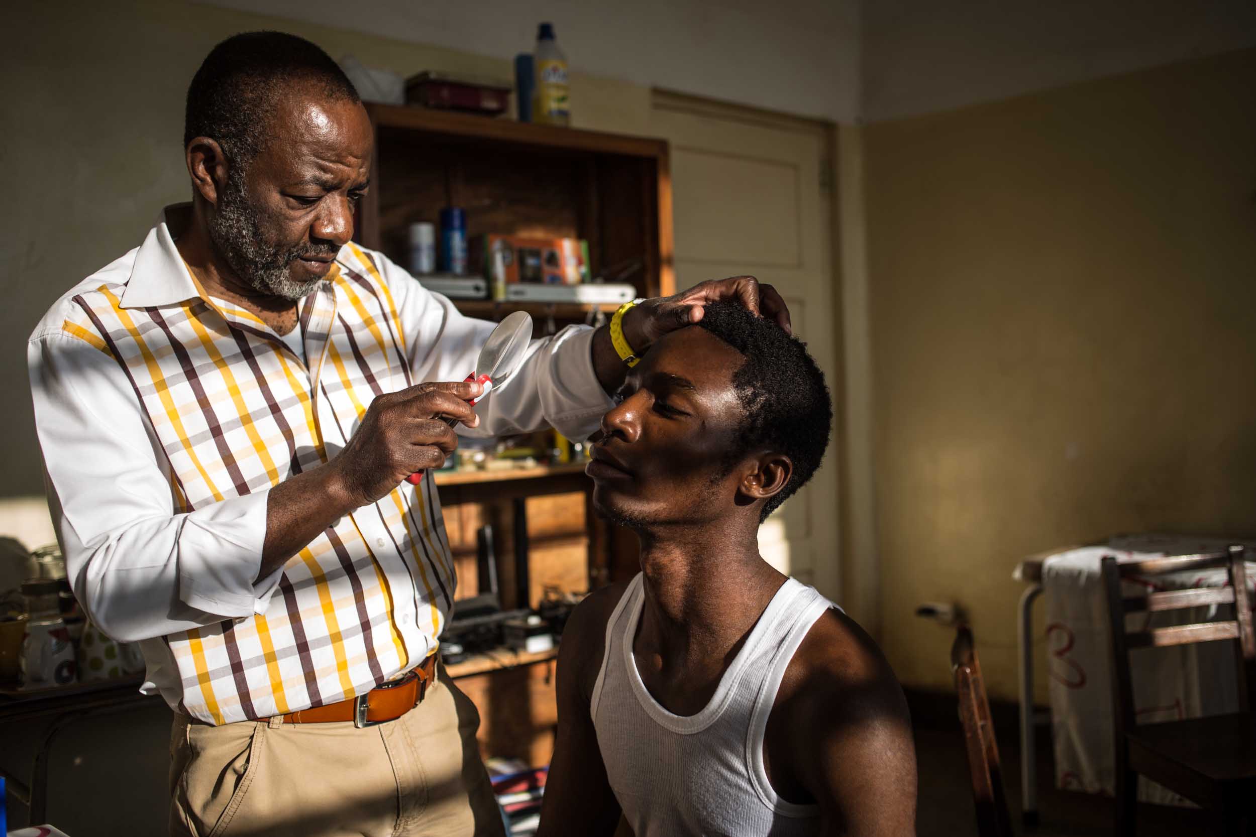  A dermatologist is  attending a young man at the Clinic Universitaire in Lubumbashi. People living close to mining companies suffer from diverse health problems like skin and respiratory diseases. 
