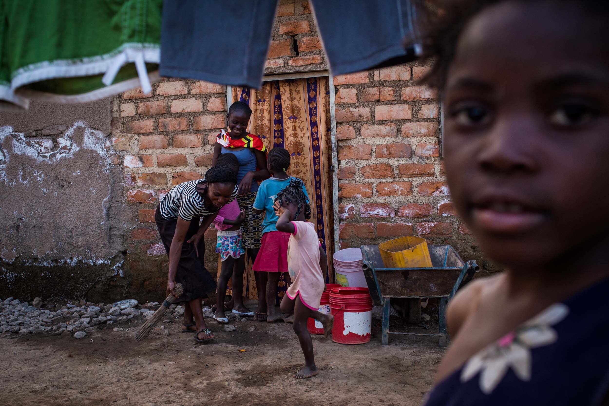  Children play outside of their house in the neighborhood of Tshamilemba, which lies close to the mining company Chemaf. The water and soil in this area are highly contaminated due to the toxic waste of this company. The white salts on the house wall