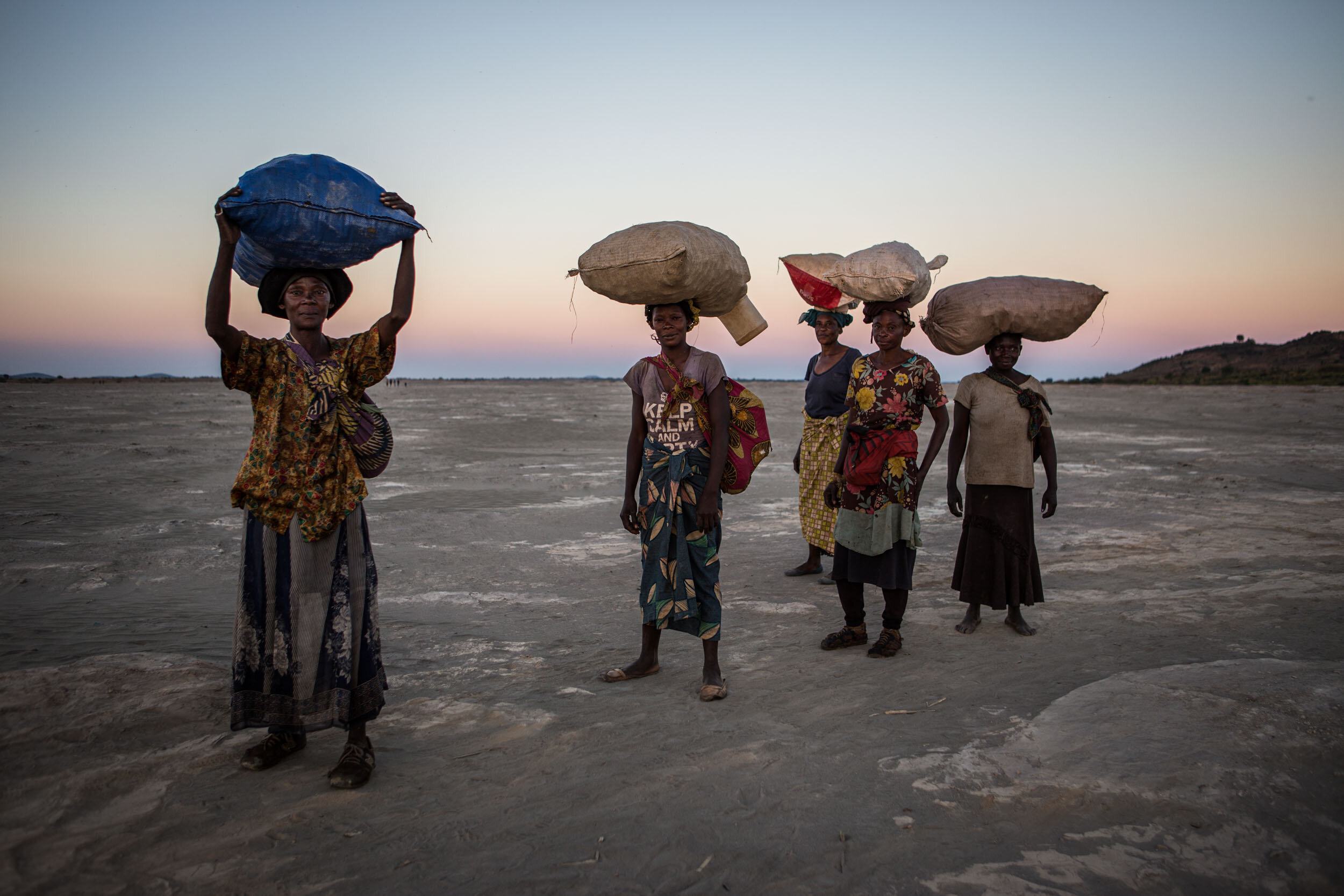  Women come back from a working day, carrying their crops in the toxic desert of Kipushi. It was formed after a mining company dumped toxic waste in 1930, killing all the vegetation. The dominant mining narrative in DRC is about conflict minerals suc