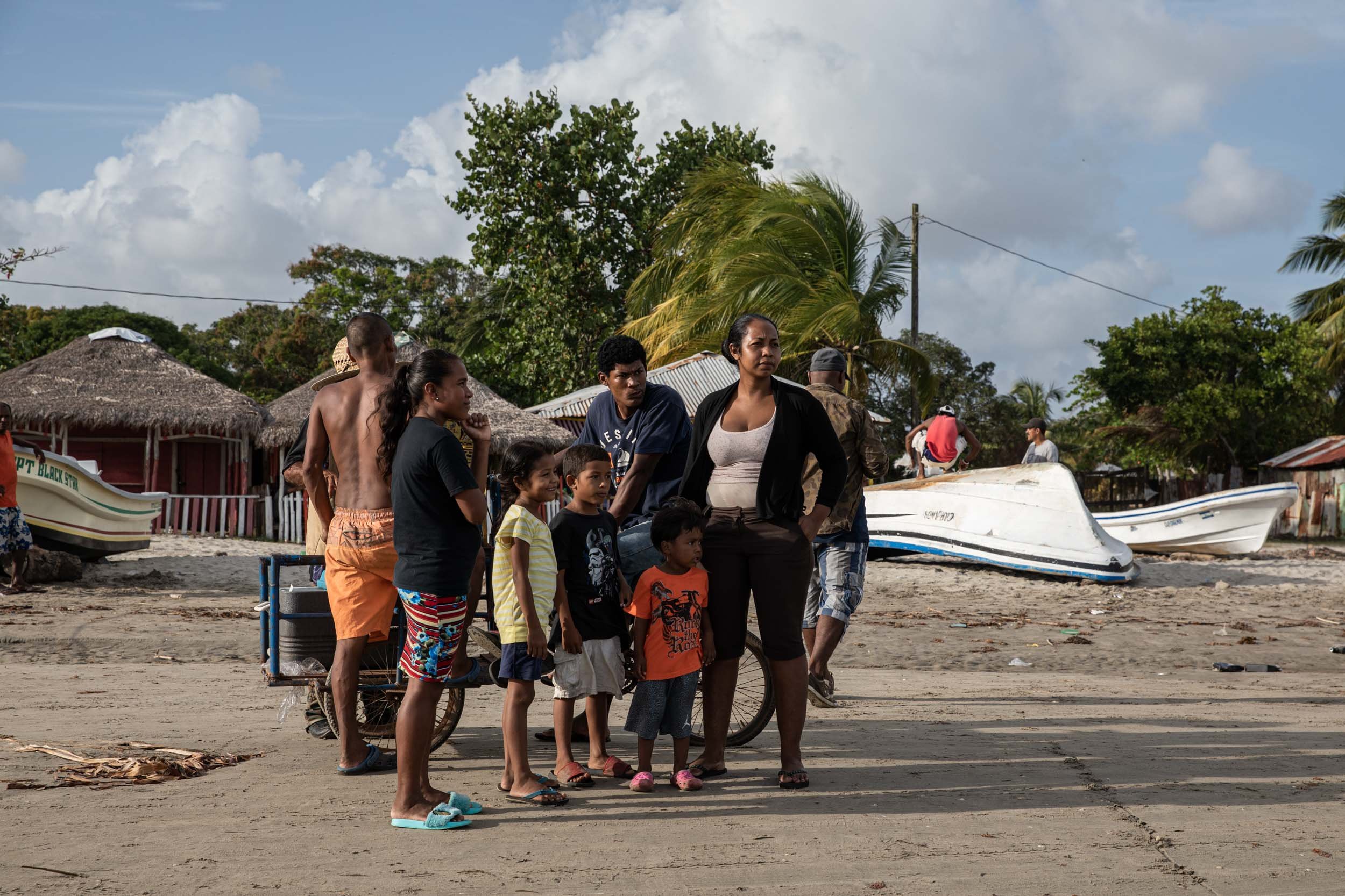  A woman stands with her son at a beach in Puerto Cabezas. Her husband is about to leave in a small boat to dive for lobster and sea cucumbers. Many women are afraid of their husbands to go diving. Not all of them come back. 