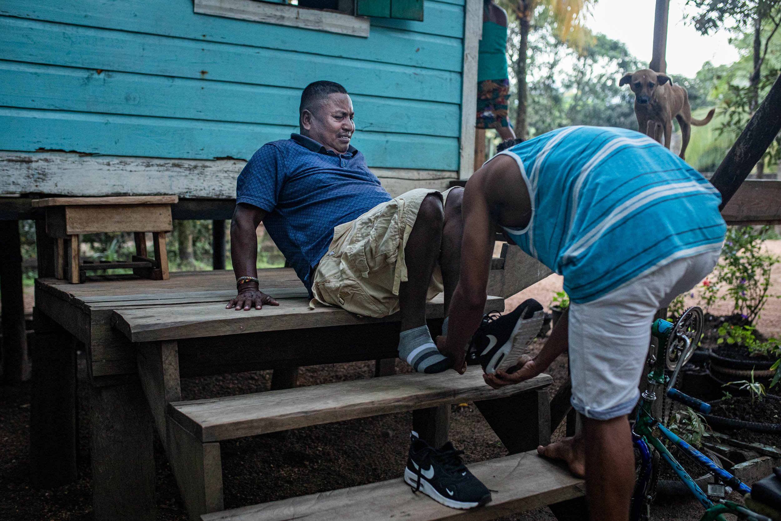  Oscar, 22, helps his father Mr. Flores to get up to his house in the evening. 