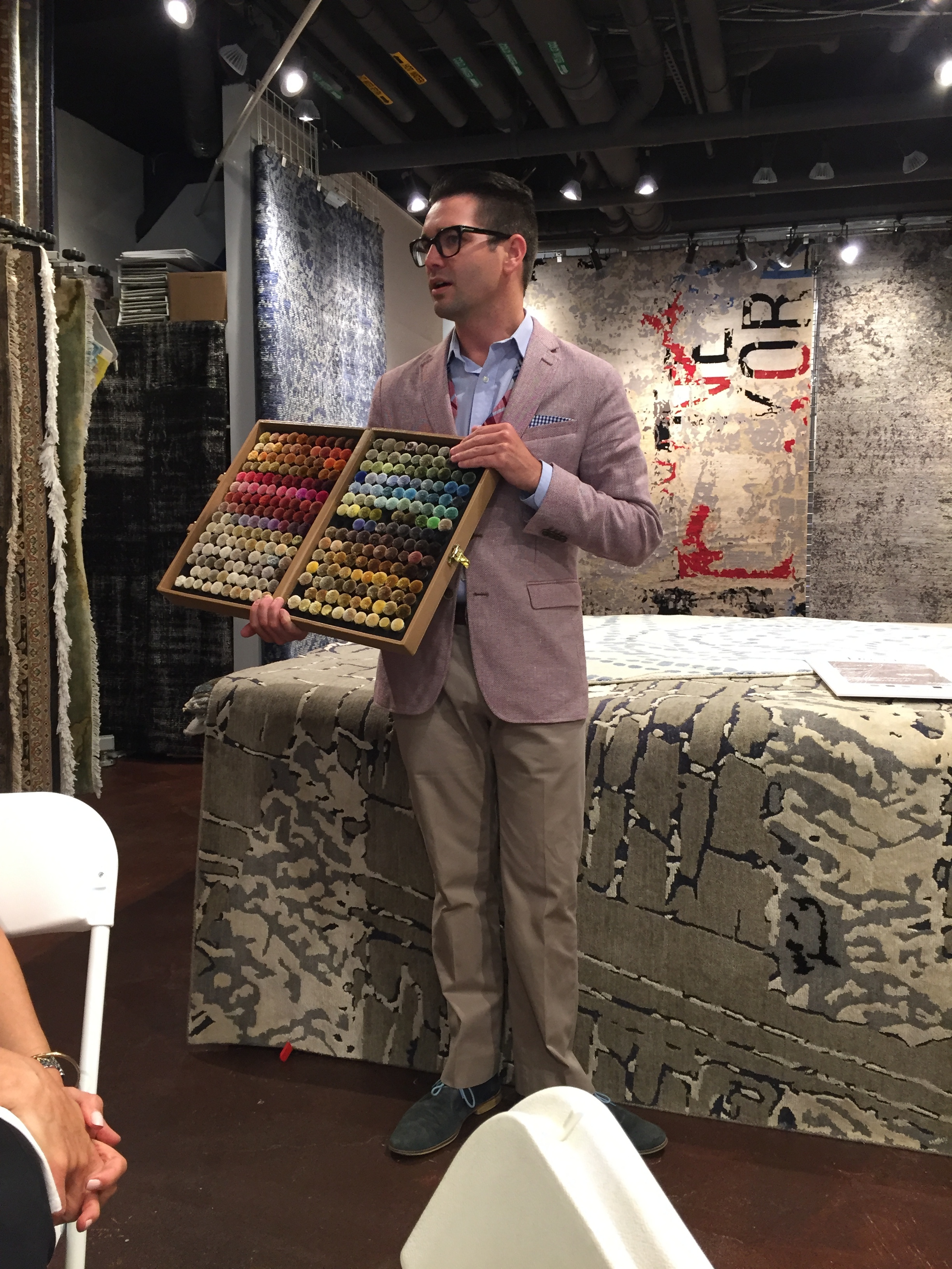 Eric showing color poms, which are available for those who would like to order rugs to match their design needs.