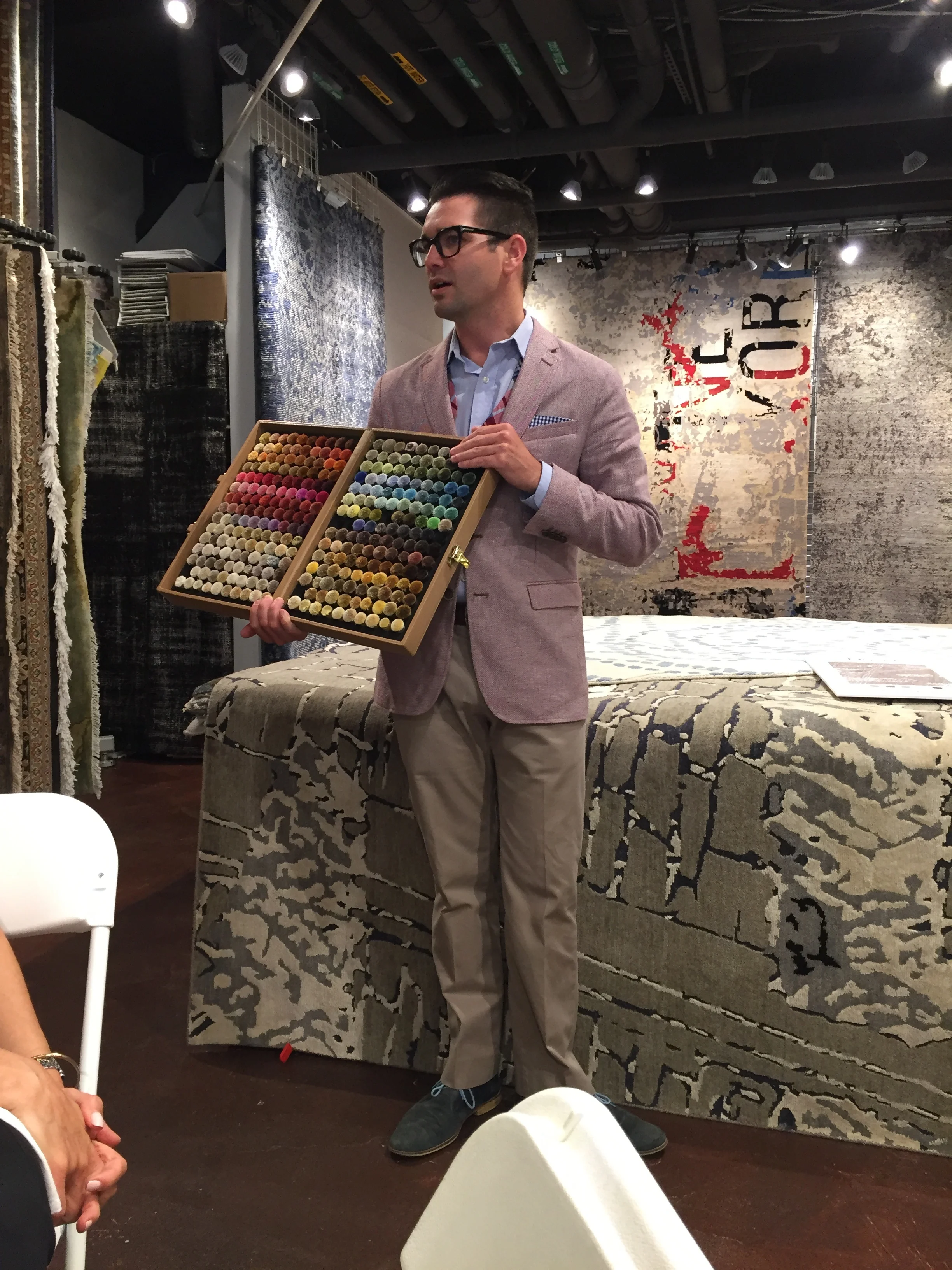 Eric showing color poms, which are available for those who would like to order rugs to match their design needs.