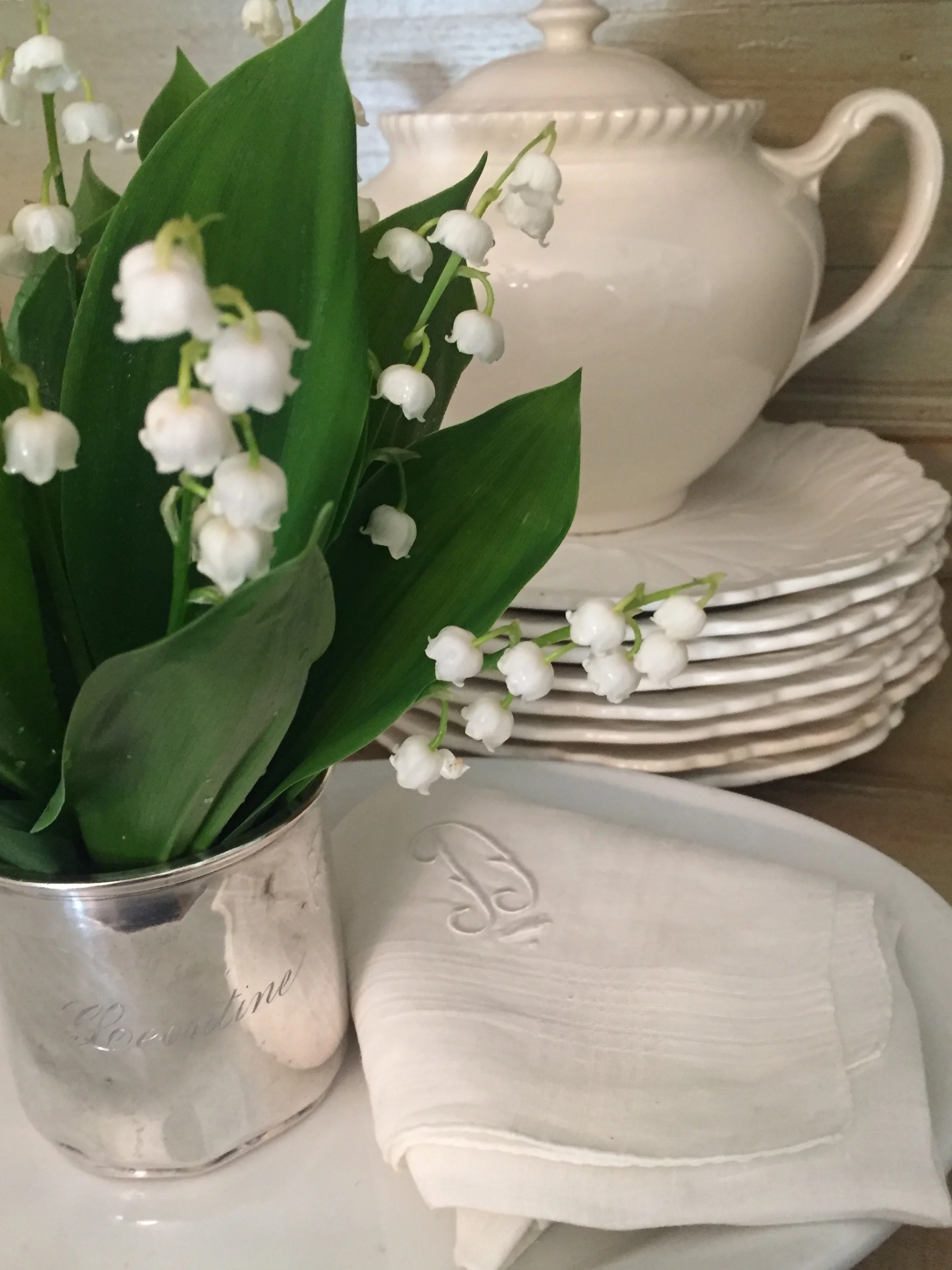 A silver baby cup takes center stage as do monogrammed handkerchiefs