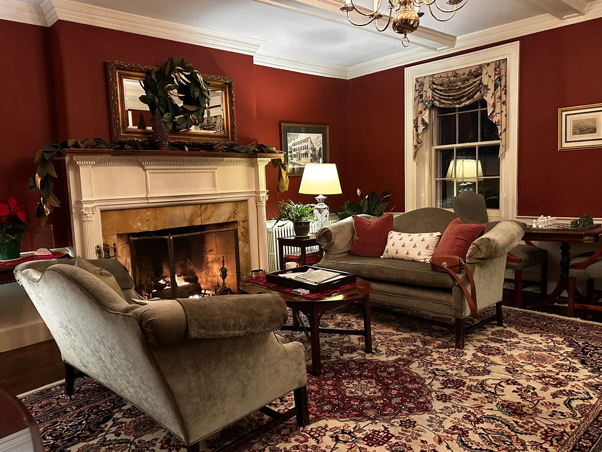 a picture of a red room with classic traditional furniture in a historic New England Inn in Marblehead MA
