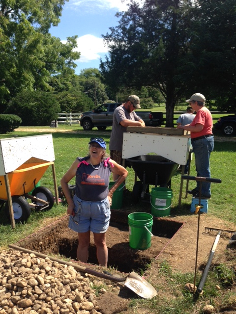 Archaeologist Esther Reed at Port Tobacco. Screening for artifacts from the ground carefully unearthed takes place behind her.