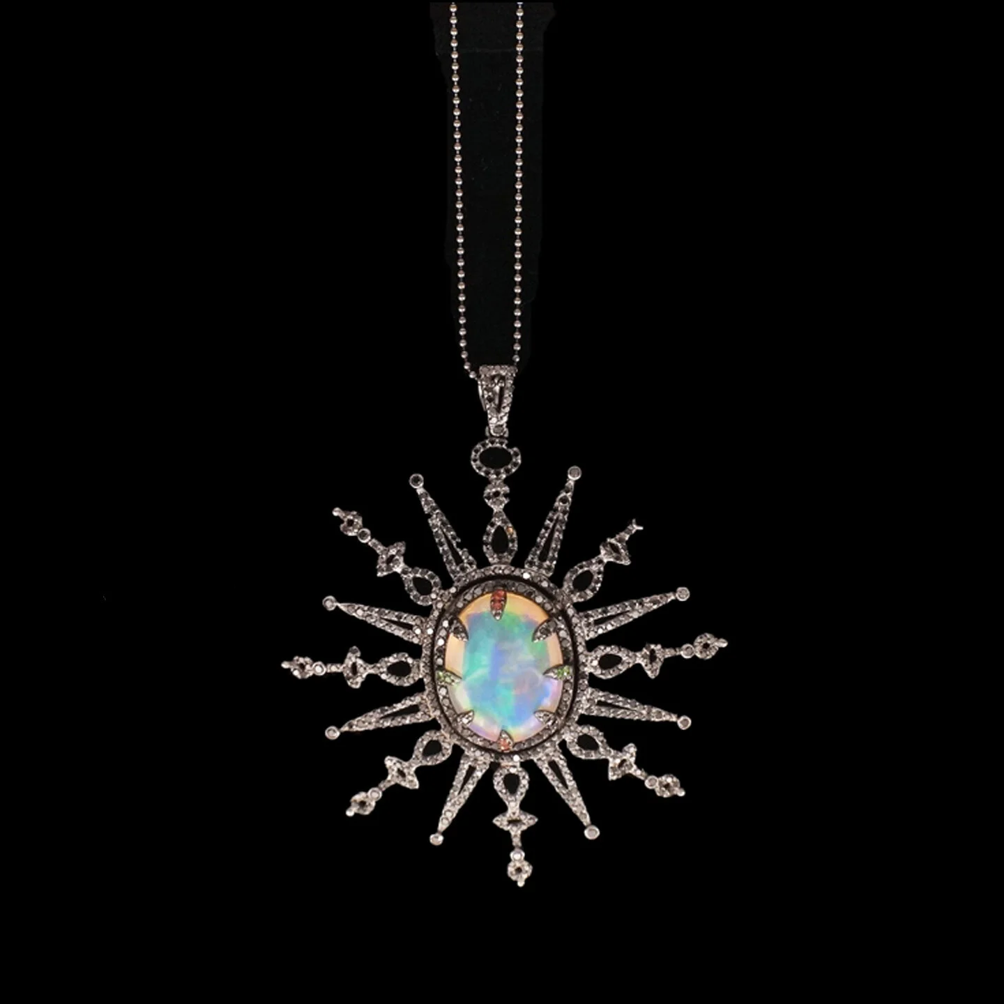  Tavous Necklace    $35,400.00       A platinum necklace showcasing a large central medallion. This primary motif, featuring a fabulous 15.28 carat oval cabochon opal, is held in place by eight prongs set with black diamonds, tsavorite garnets, and o