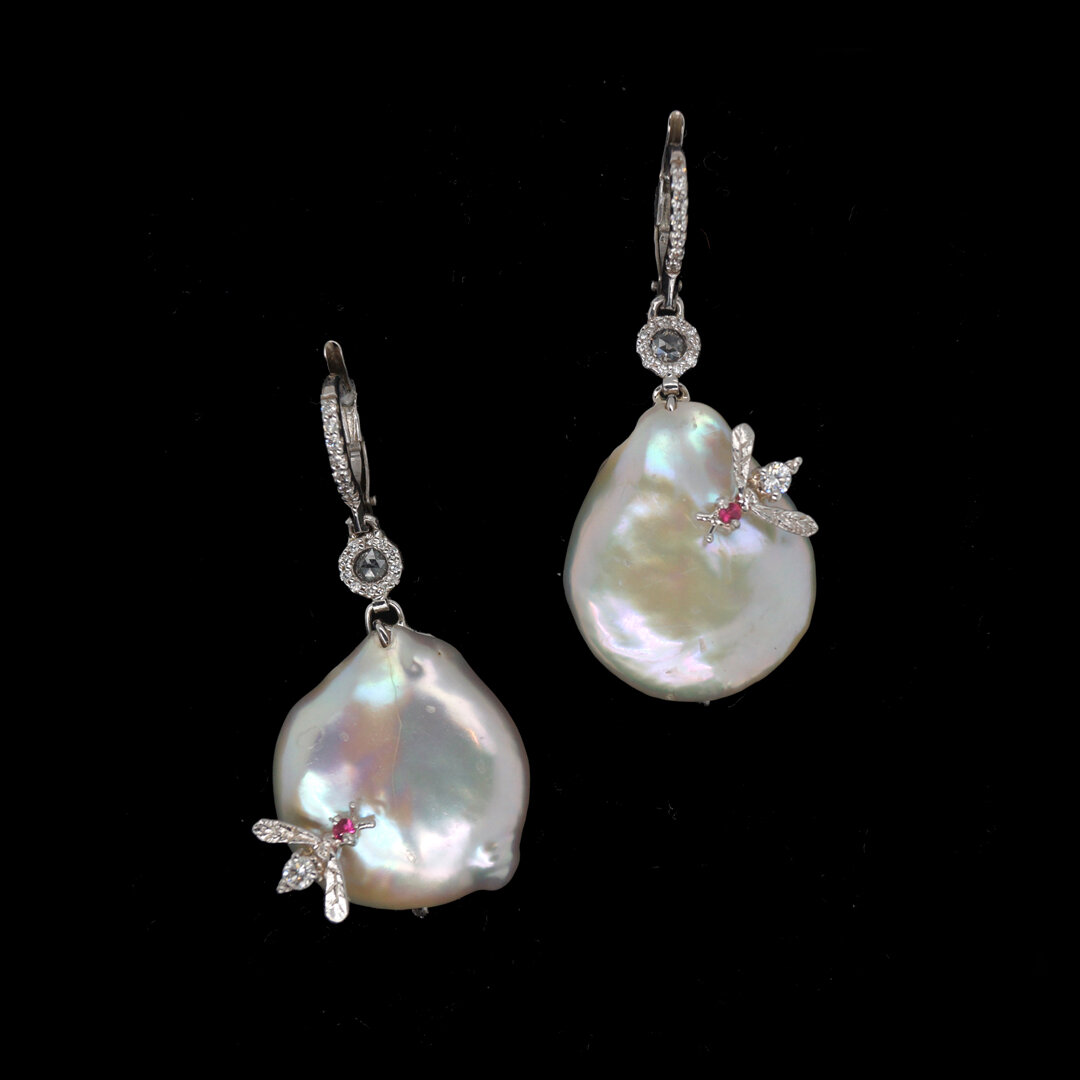  Pearl and Diamond Bee Earrings   $11,900.00     A pair of  pearl and white diamond earrings, set in eighteen-karat white gold.  A bumblebee, set with a round faceted ruby and a round white diamond, has been whimsically placed on each earring.     Th