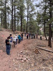 Tour attendees walk along a section of unfinished trail in the Quartz Hill area.