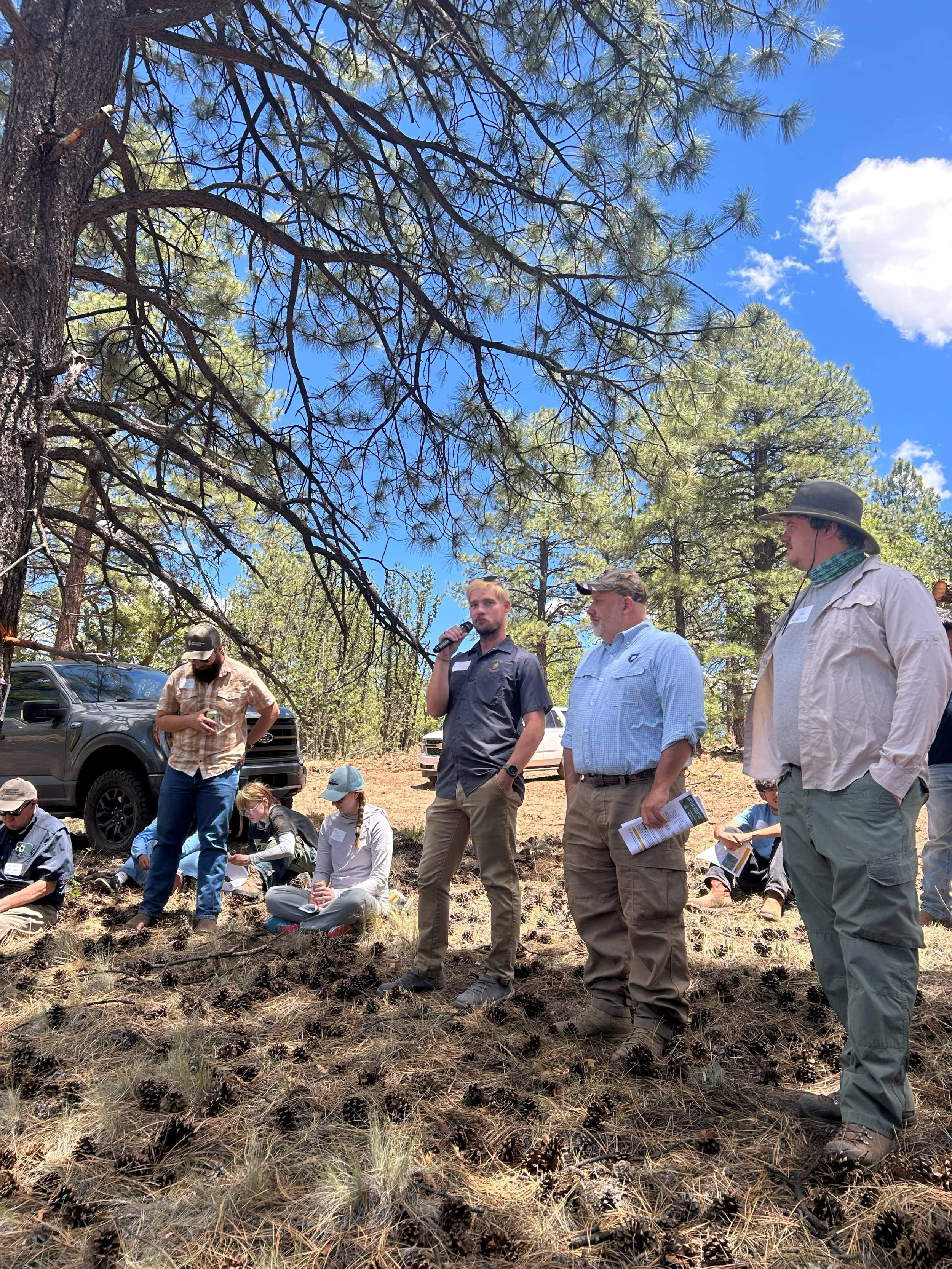  Clay Benton, C.O.O. with Forest Fitness (center left), and Todd Haines, inspector with Nation Wild Turkey Federation (center right) took turns speaking about the logistics of forest thinning and timber harvesting at the second tour stop 