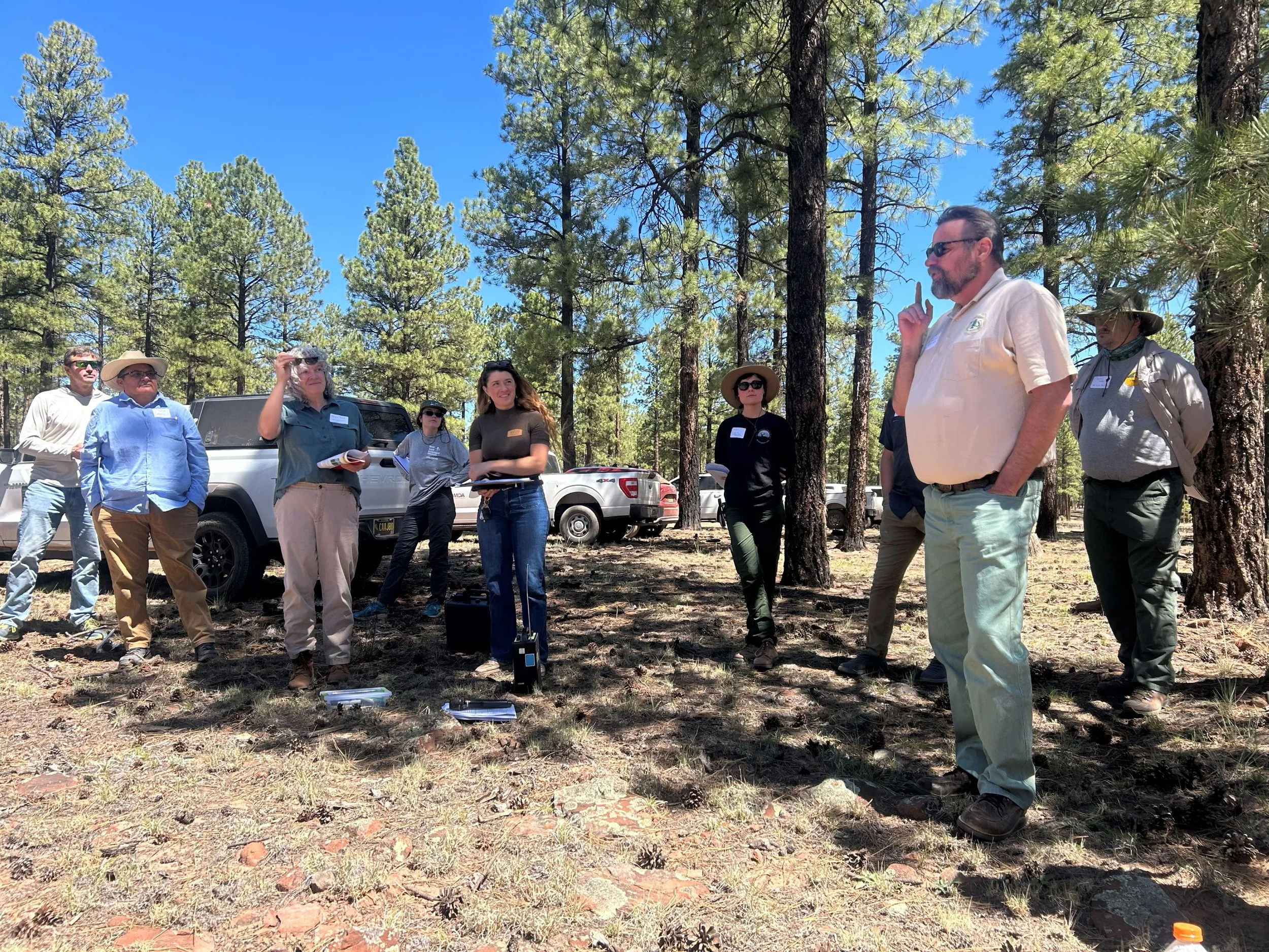  Bryce Esch (center left) and Jay Turner (right) opened up the first stop on the tour with a welcome and discussion of the national Collaborative Forest Landscape Restoration Program (CLFRP) 