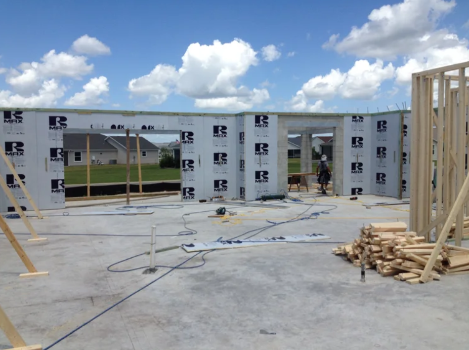 Concrete slab foundation with RMAX insulation panels installed on the perimeter walls of a house under construction.
