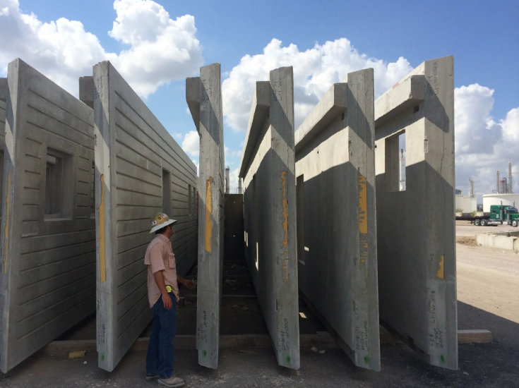Precast concrete panels prepared for block wall insulation installation at construction site.
