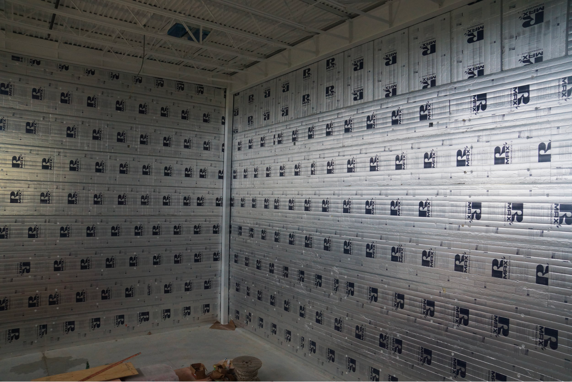 Interior corner of a building fully lined with RMAX foil-faced insulation panels.