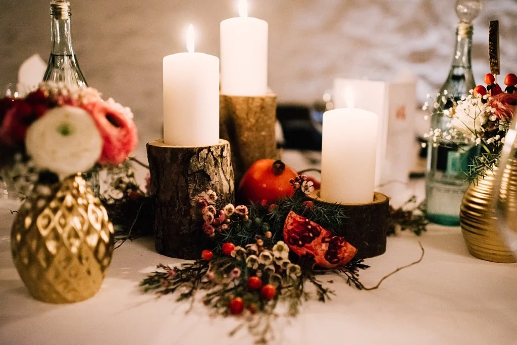 Winterliche Dekoration mit Holz, Gold und Granatäpfeln