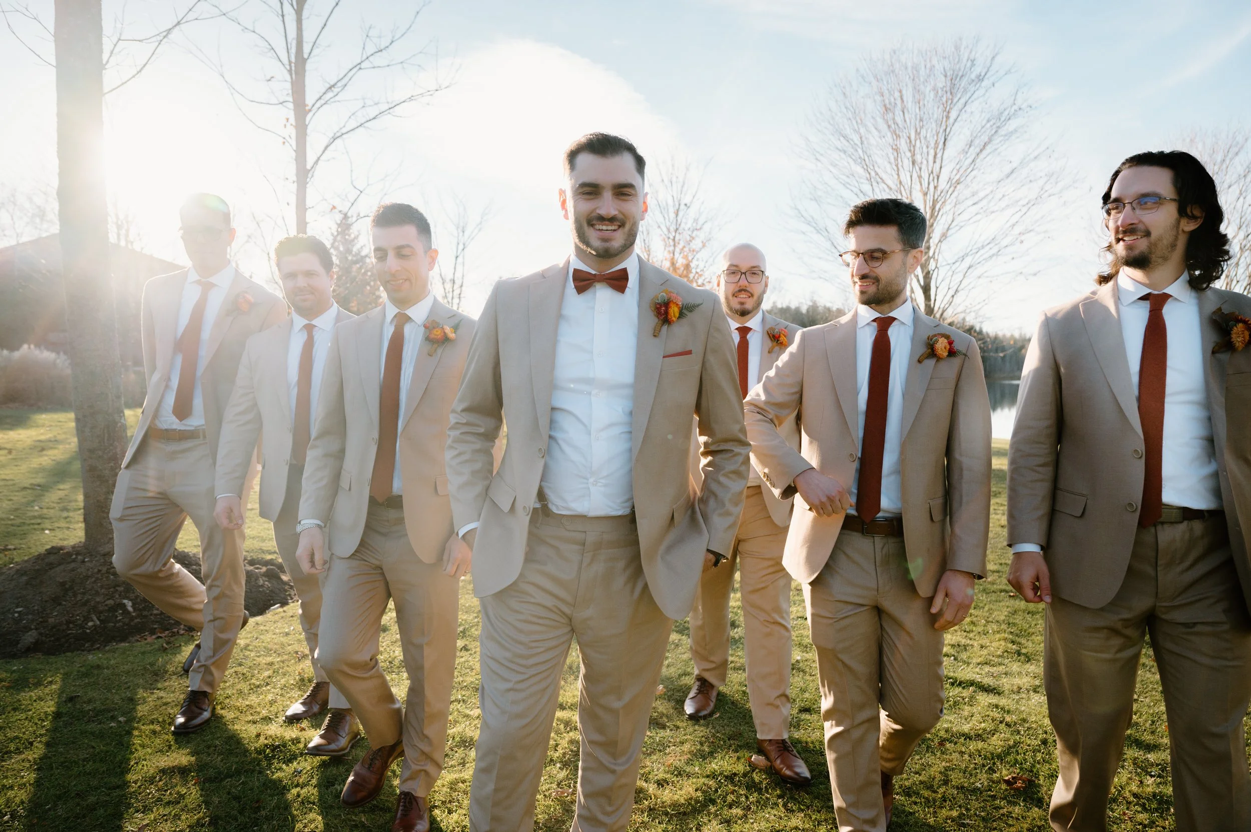 Candid photo of a groom and his groomsmen walking together at sunset at the Royal Ambassador in Caledon