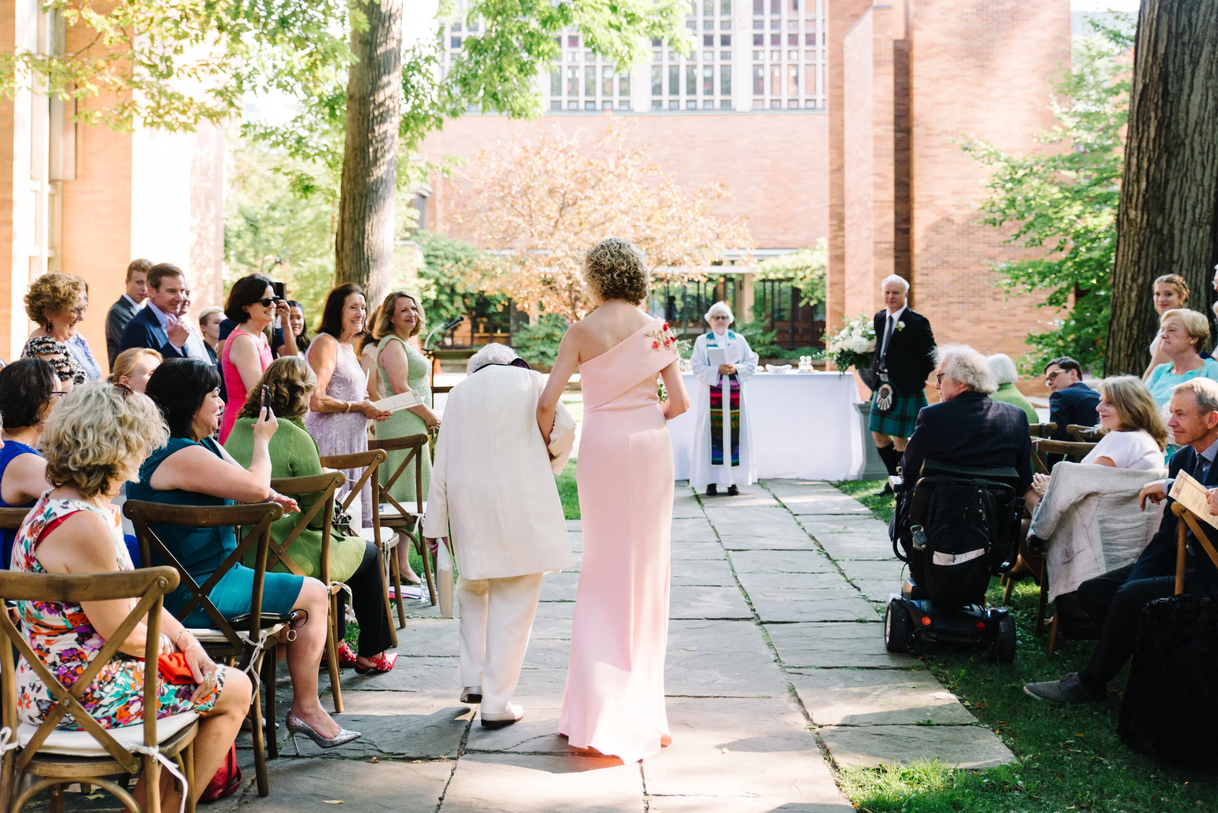 Bride walking down the aisle with her mom at Massey College Toronto wedding