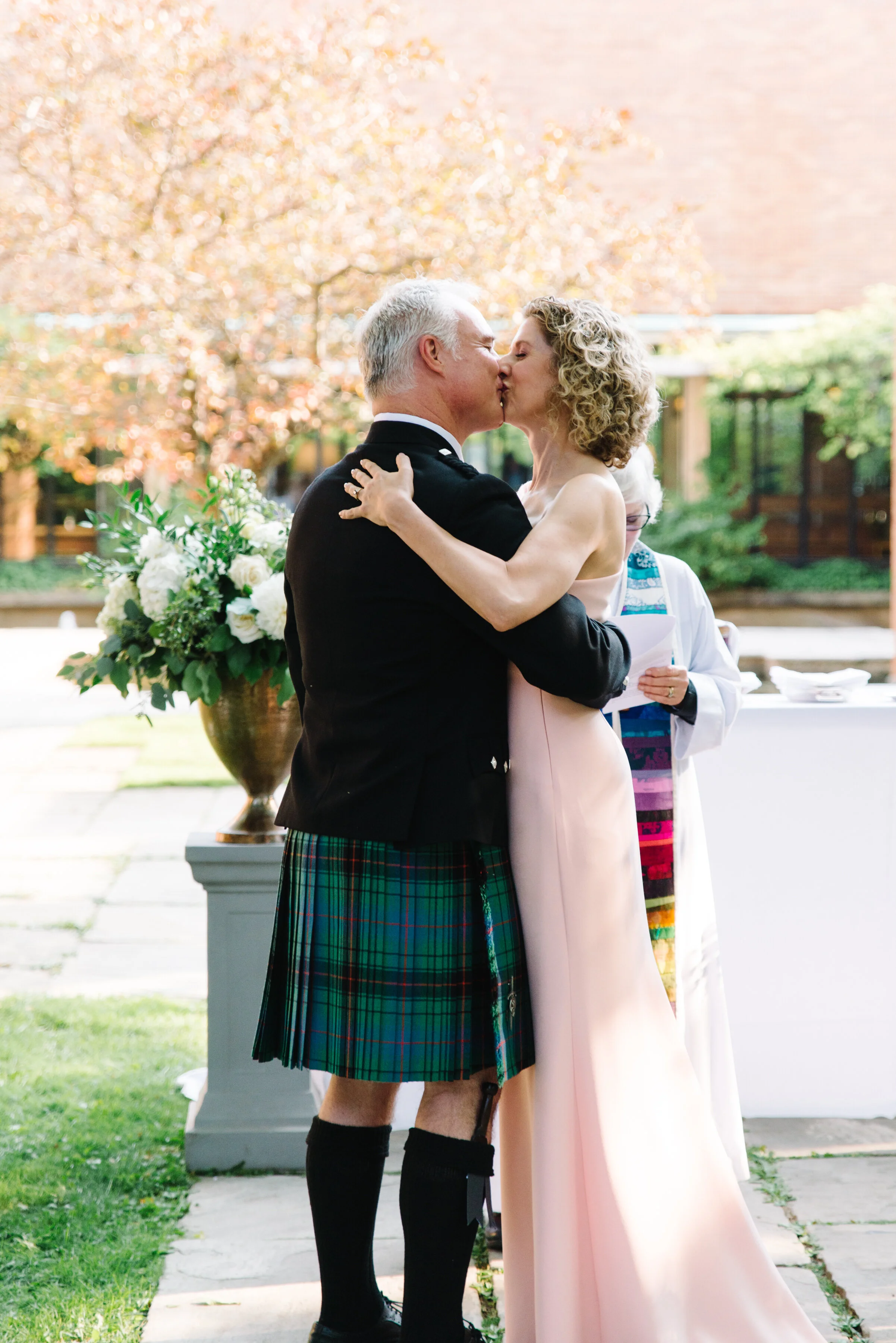 Bride and groom first kiss at Massey College Toronto wedding ceremony