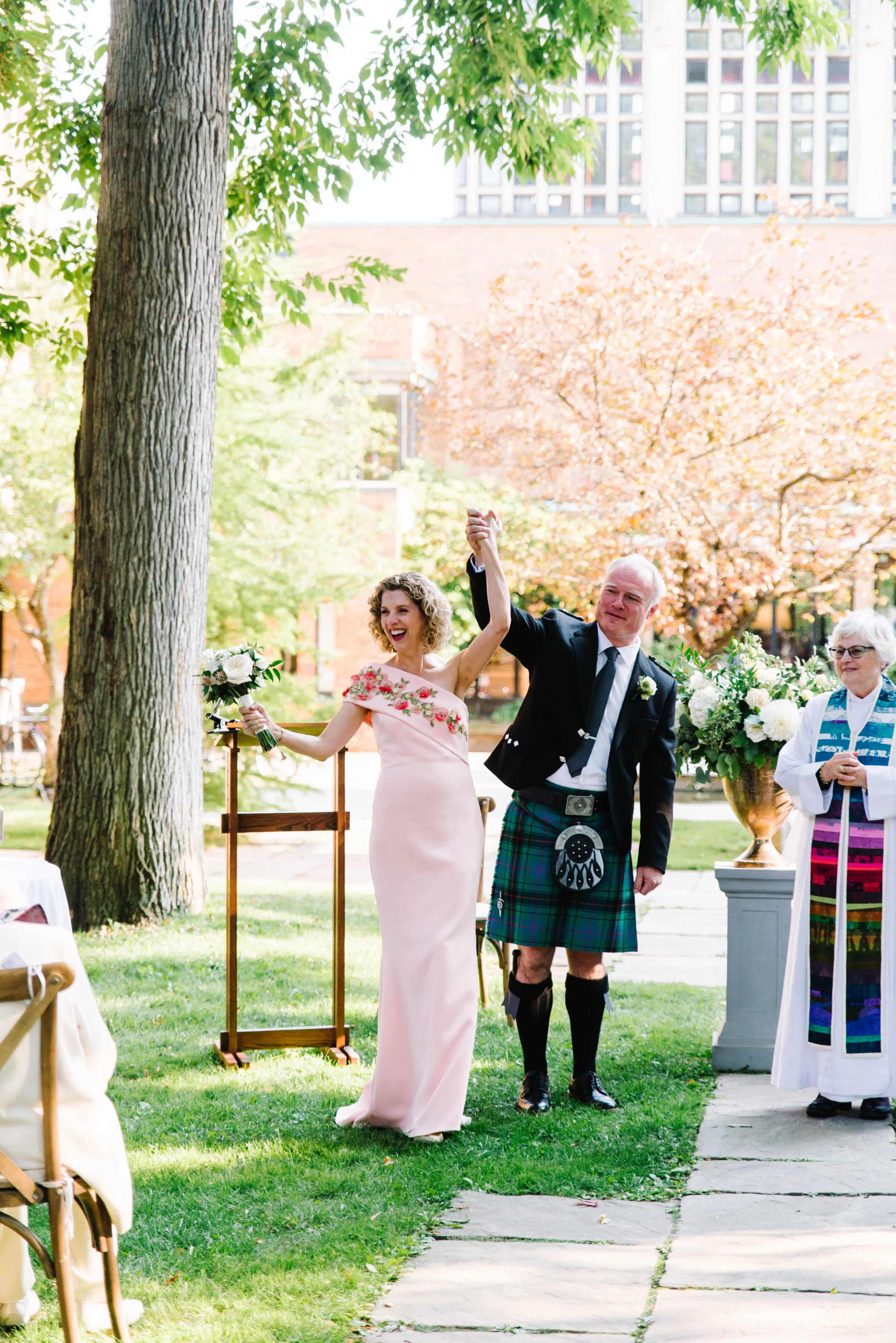 Bride and groom celebrating at the end of their Massey College wedding ceremony