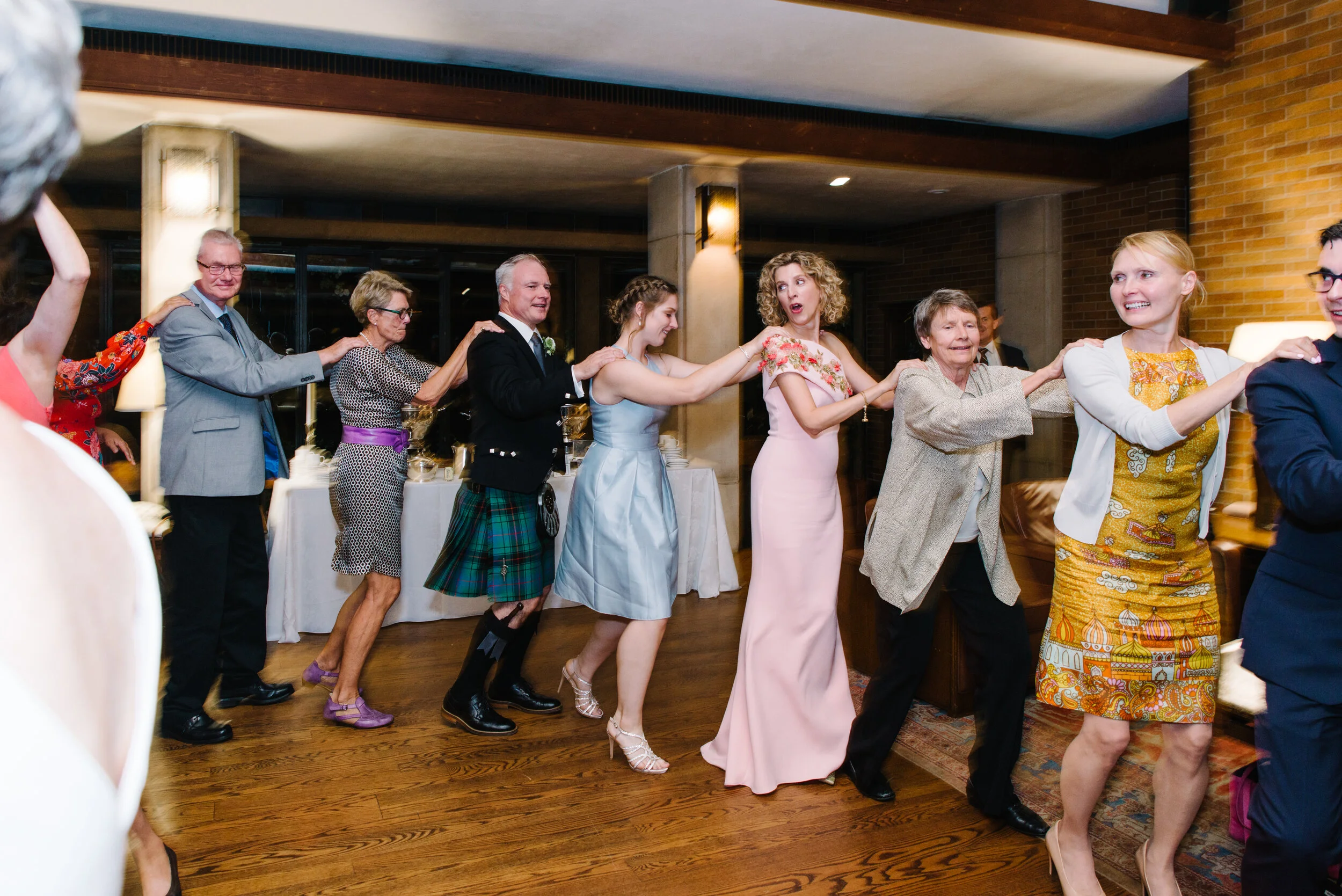 Wedding guests dancing at intimate Massey College Toronto wedding reception