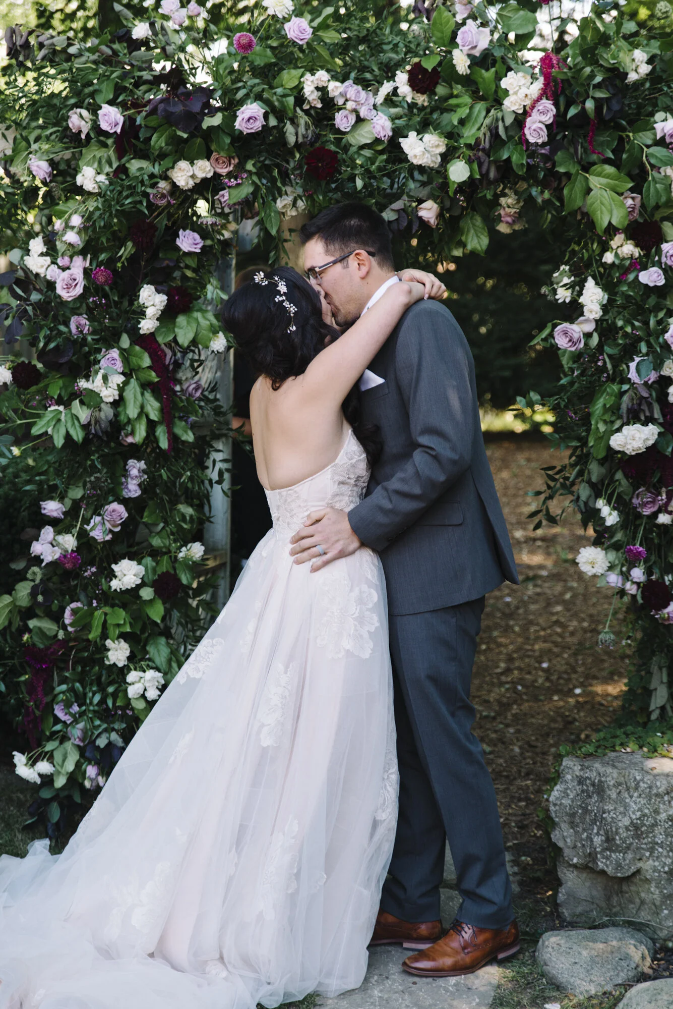 Bride and groom sharing their first kiss during an intimate backyard wedding ceremony in Toronto