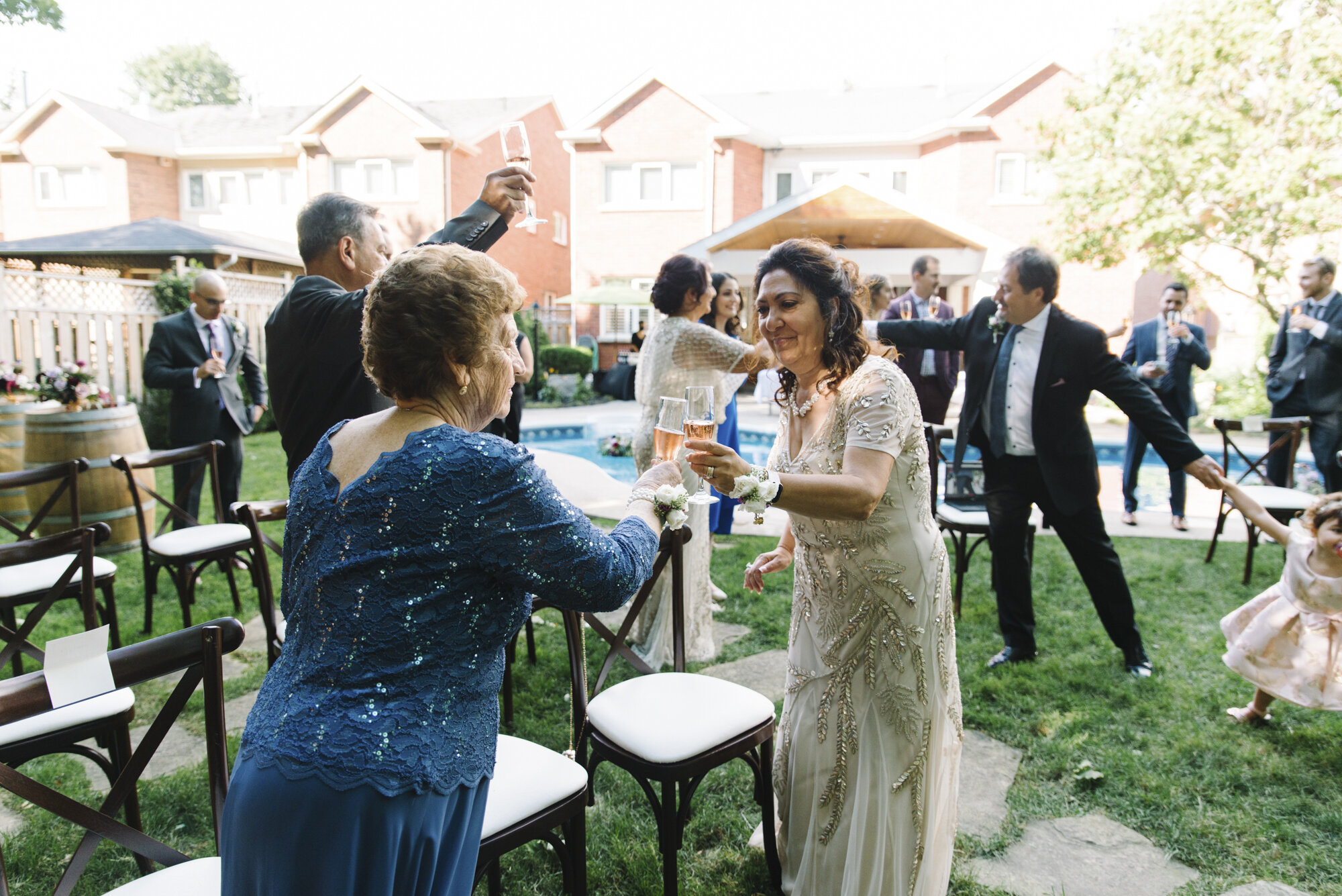 Candid photo of guests joyfully celebrating after an intimate backyard elopement ceremony in Mississauga