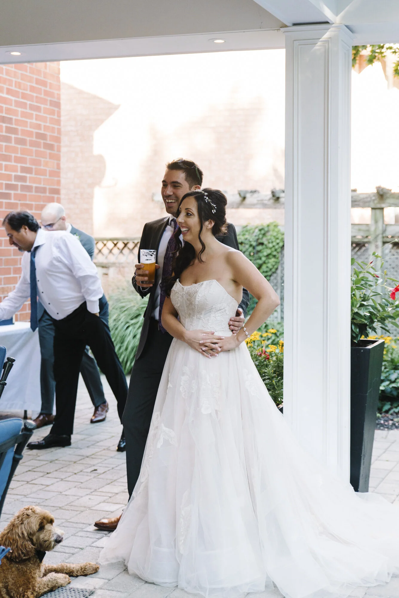 Candid photo of a bride and groom listening to a heartfelt speech during their intimate backyard elopement reception