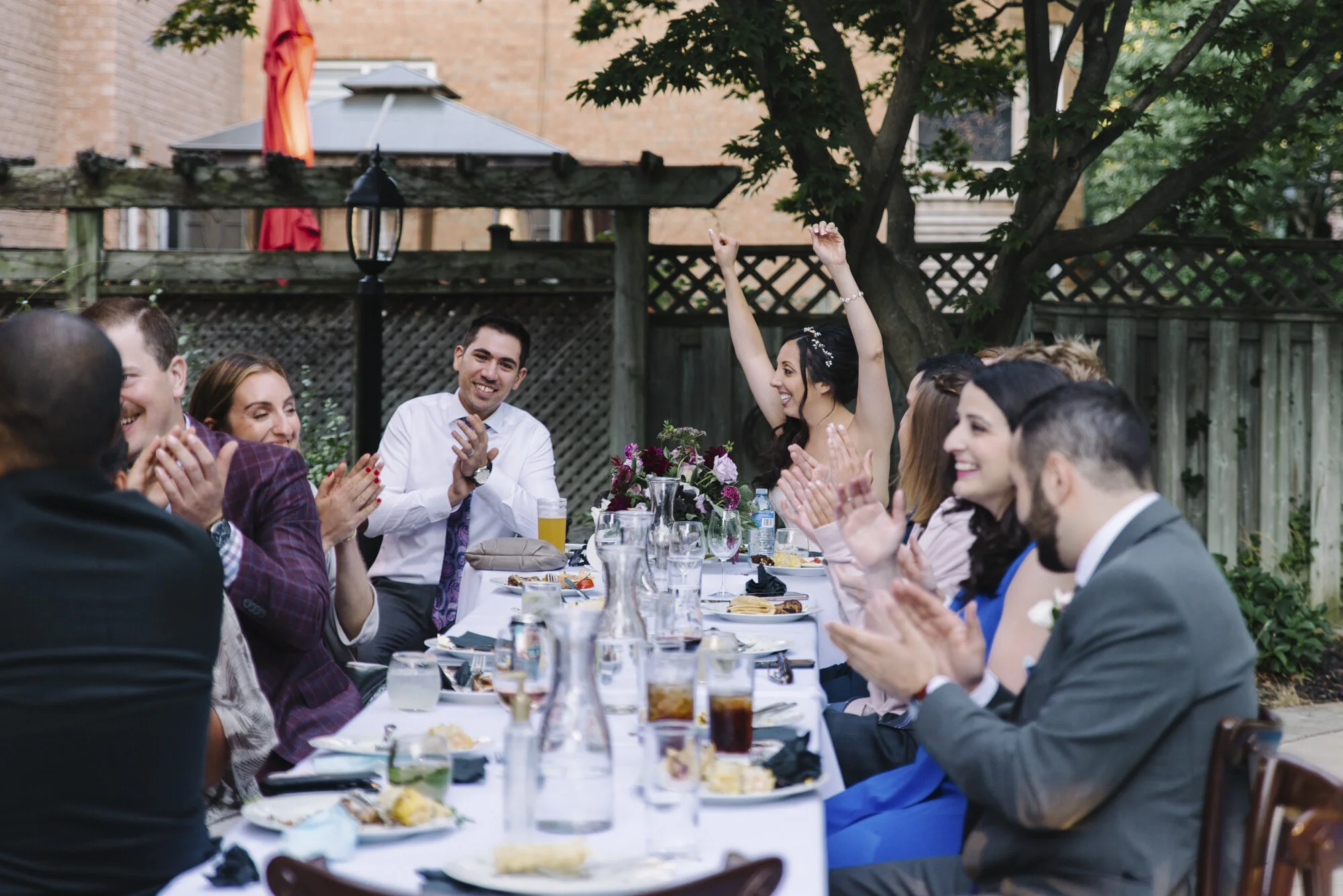 Candid documentary photo of guests mingling during an intimate backyard wedding reception in Toronto