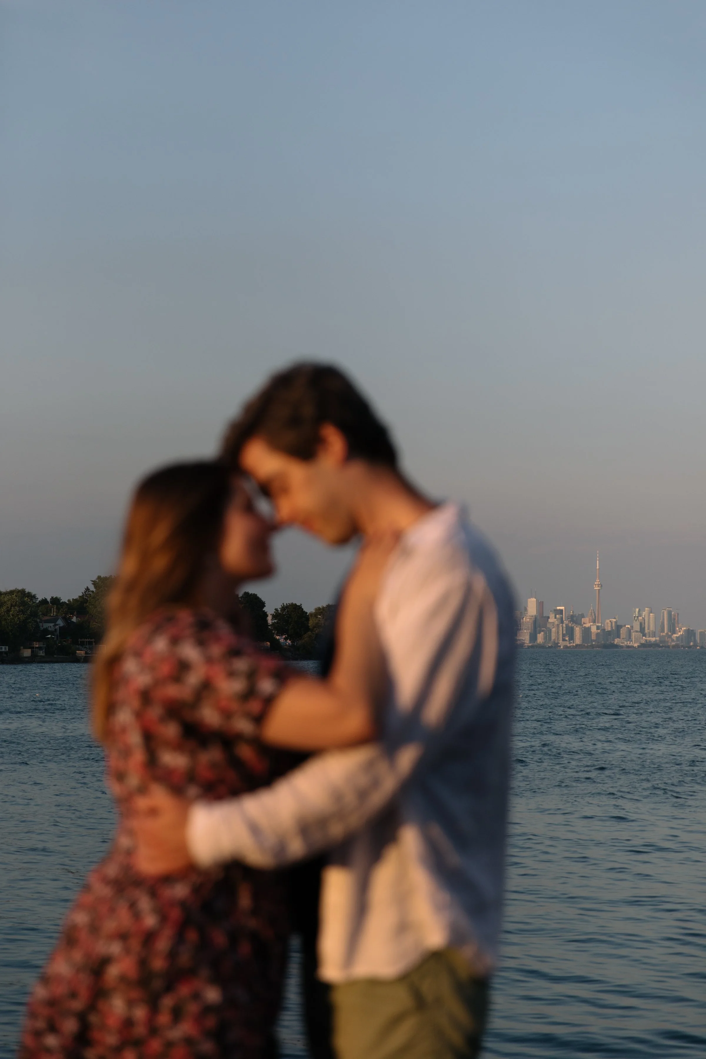 Couple posing with the Toronto skyline in the background during a sunset engagement session