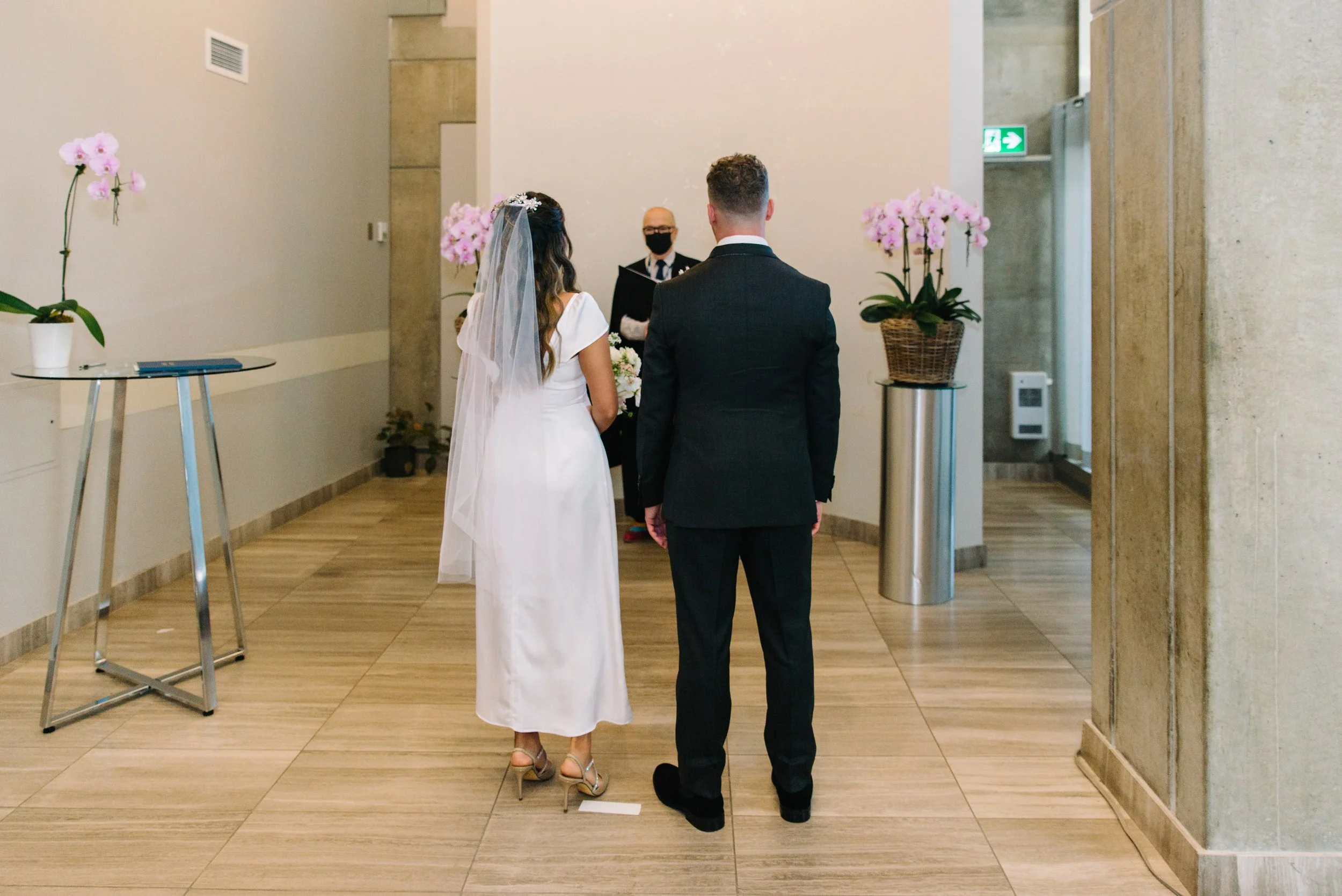 Documentary style photo of a bride and groom during their intimate elopement ceremony at Toronto City Hall