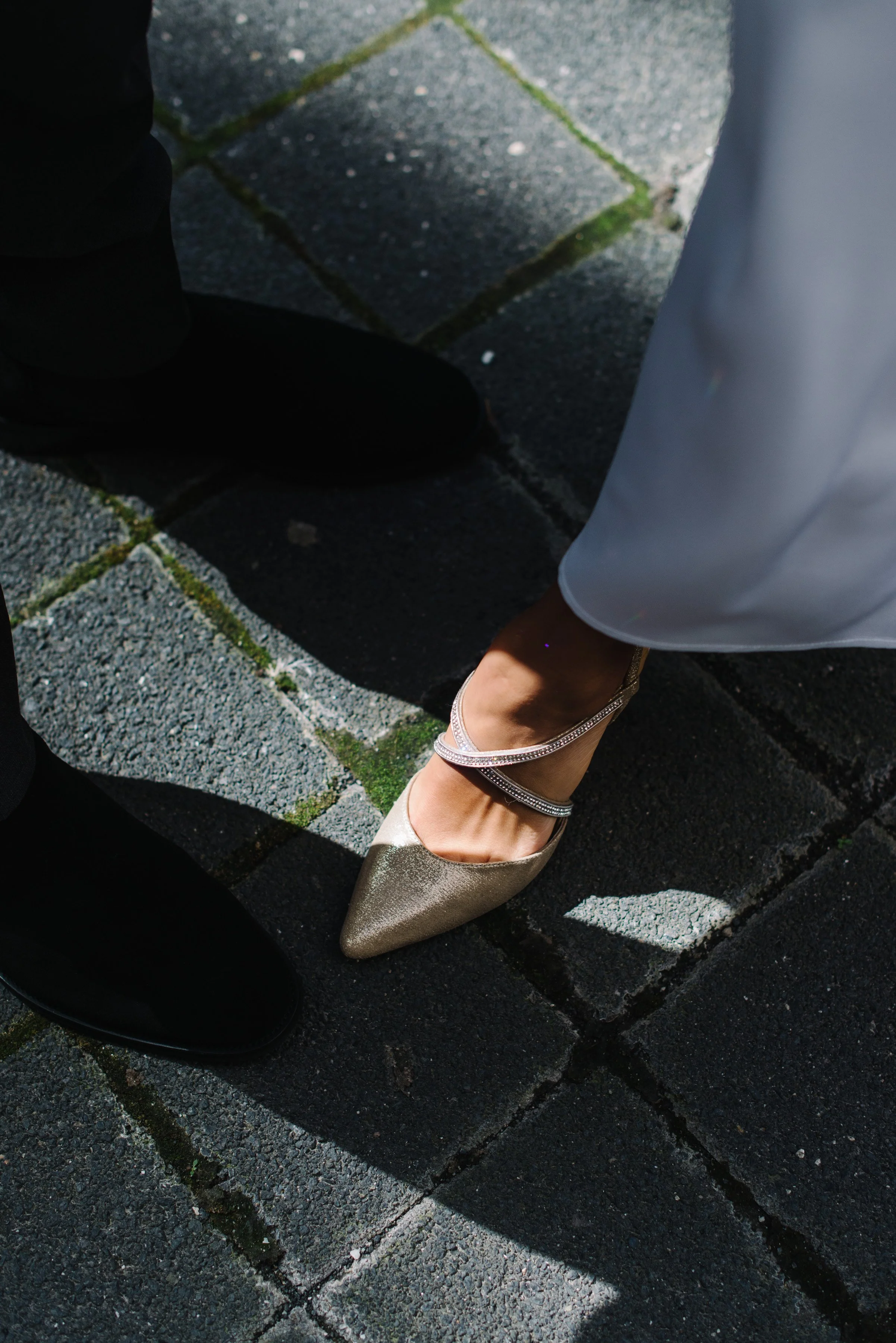 Detail photo of a bride's shoes in dramatic lighting on her elopement day in Toronto