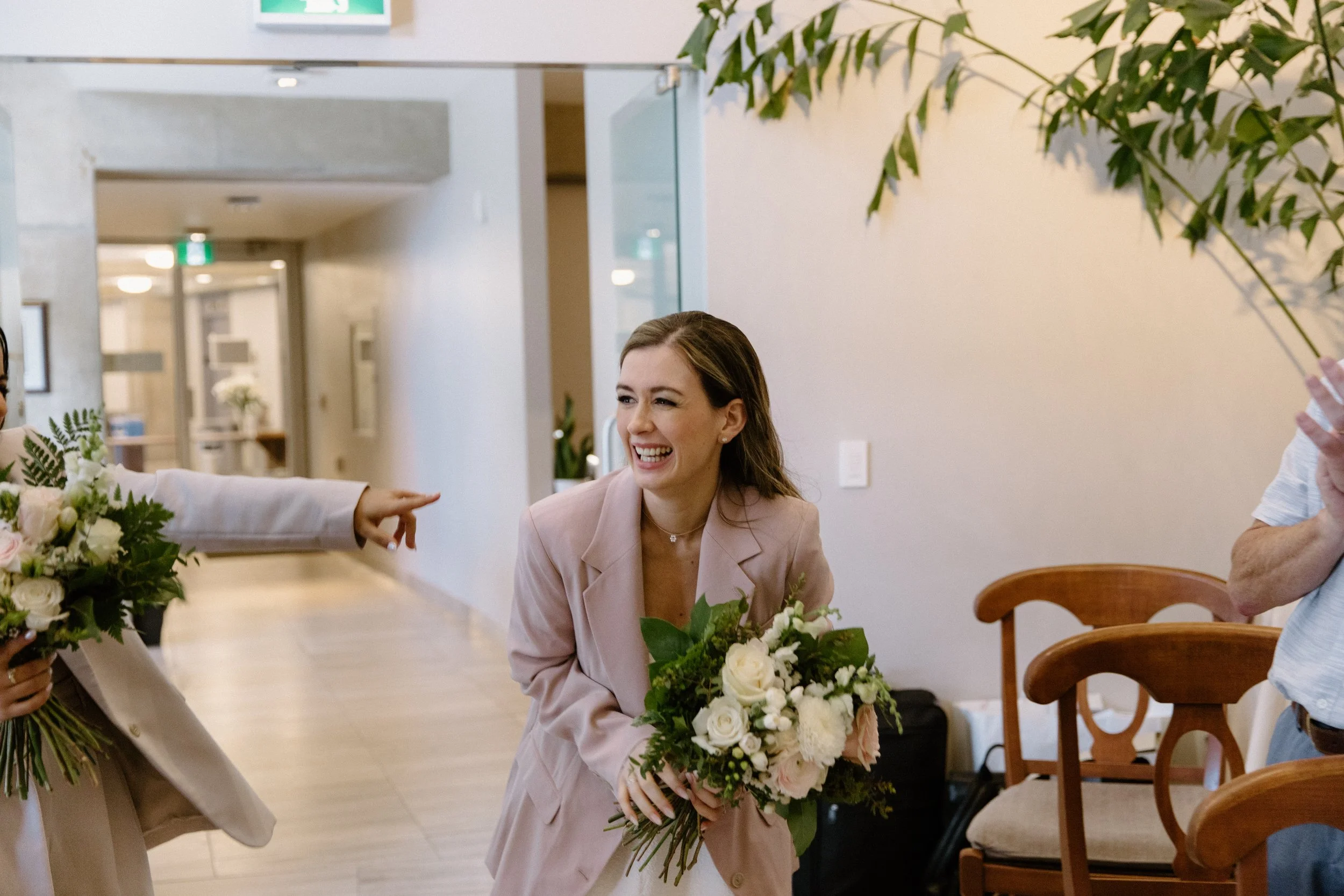 Emotional candid of two brides walking down the aisle smiling and overjoyed at their Toronto City Hall elopement