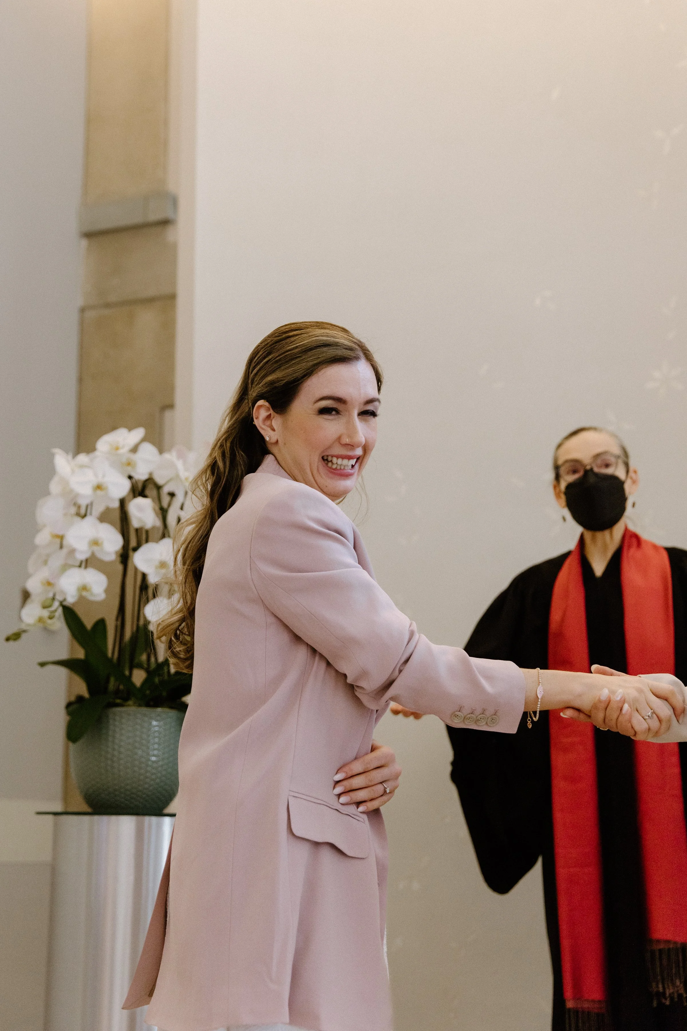 Candid emotional photo of a bride overwhelmed with joy during her same-sex wedding ceremony at Toronto City Hall