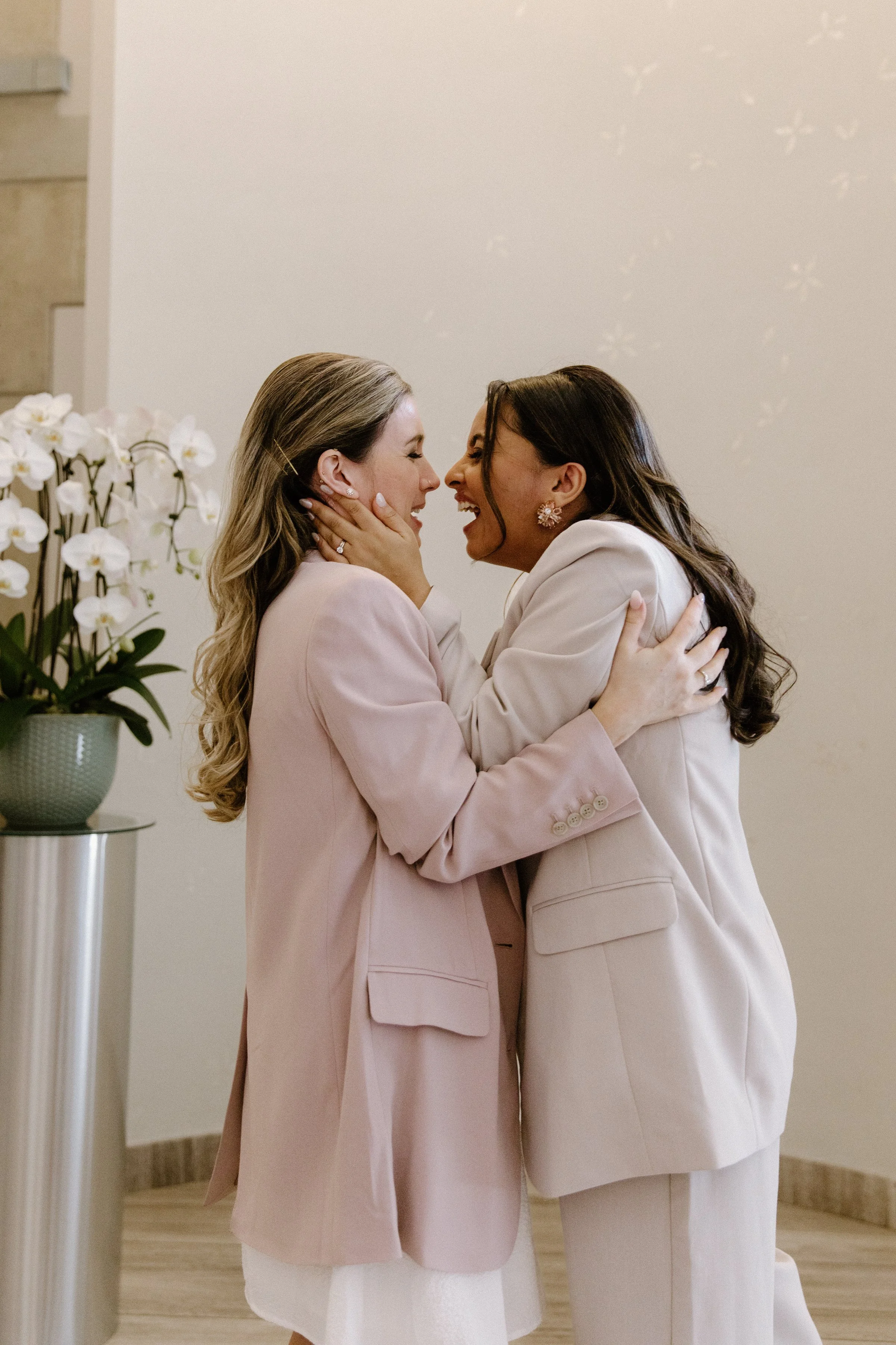 Emotional candid of two brides overjoyed immediately after their first kiss as a married couple at Toronto City Hall