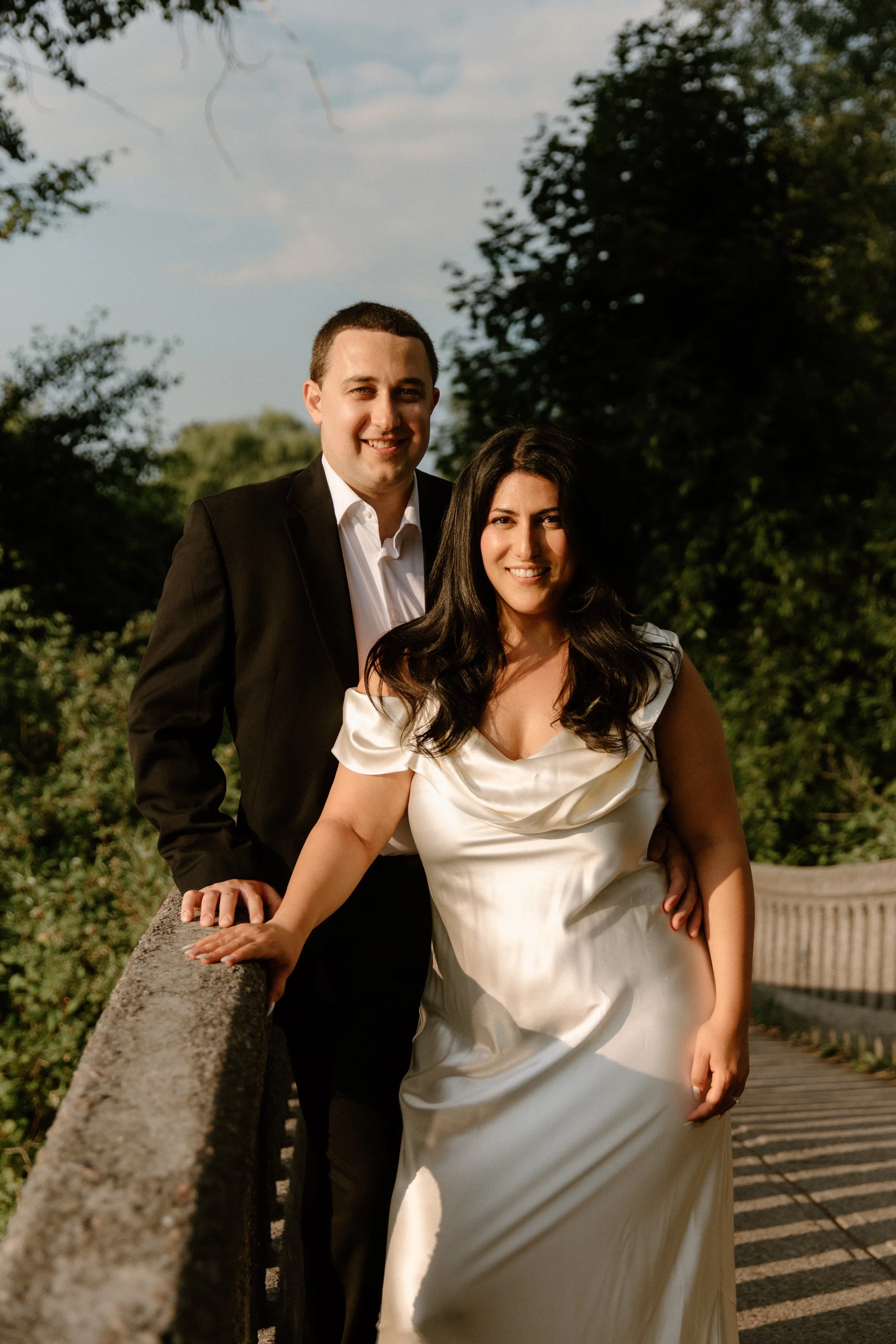 Modern engagement portrait of a couple smiling on a bridge at Centre Island, Toronto