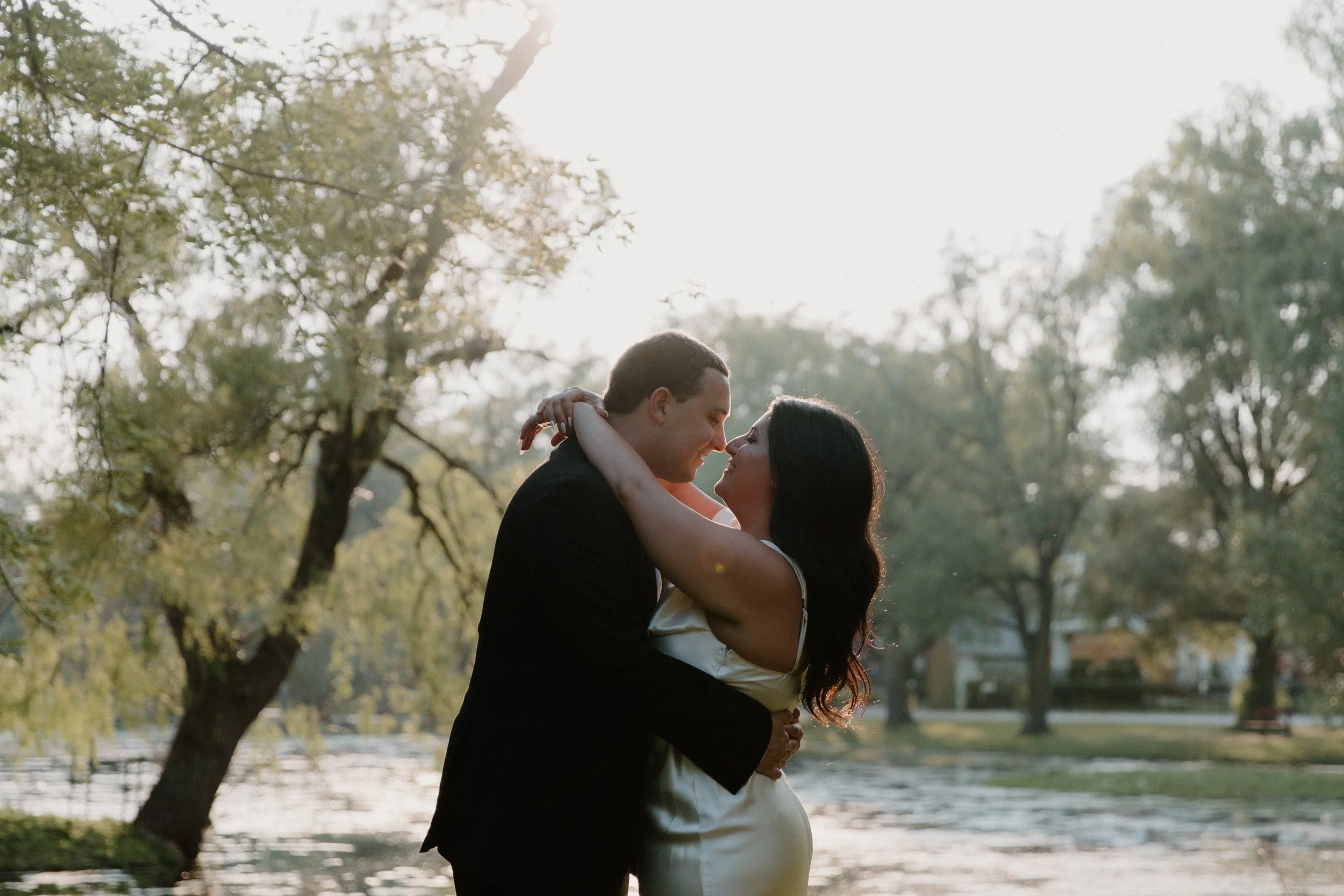 Chic elopement portraits of a couple embracing at the waterfront during sunset on the Toronto Islands