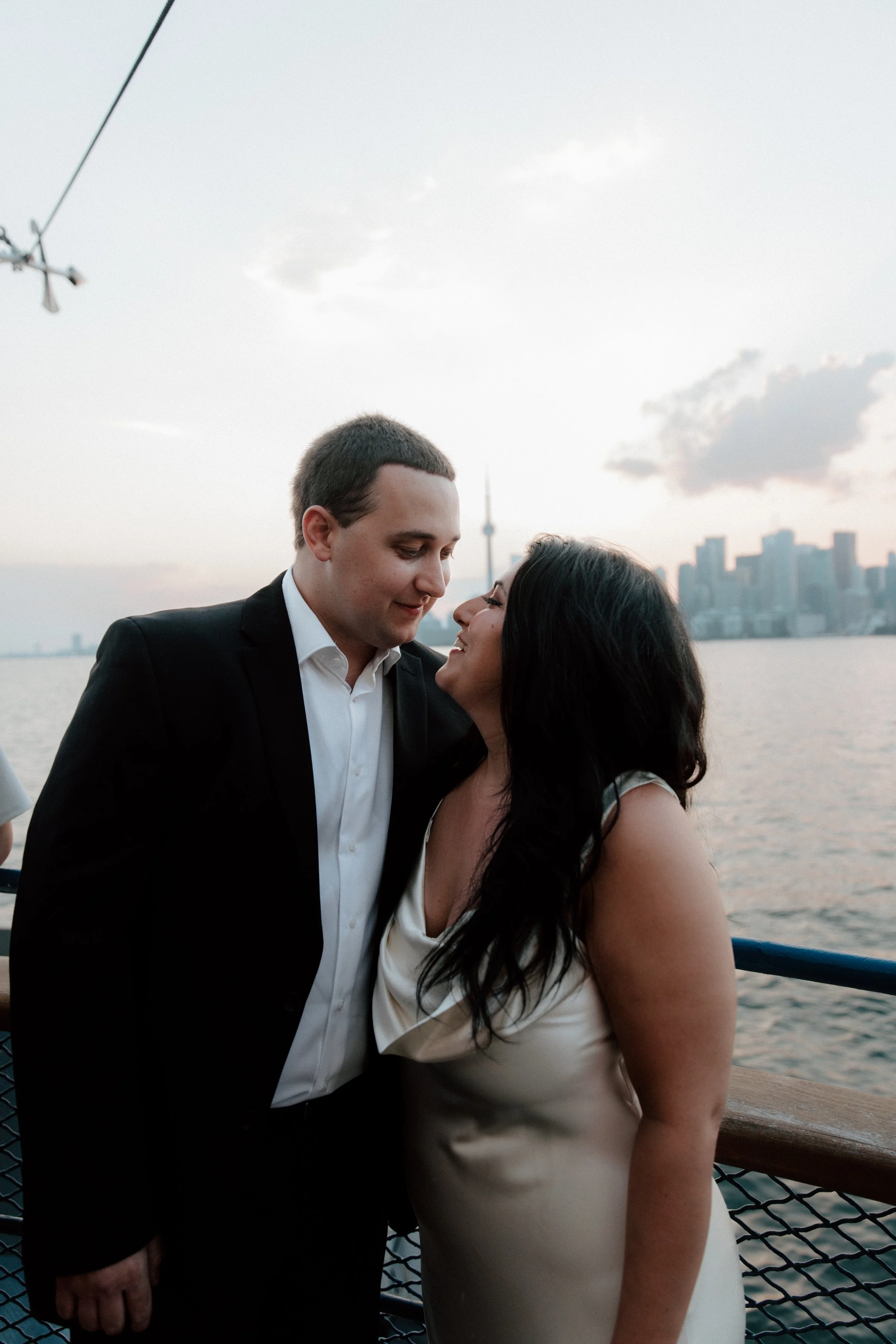 Engaged couple on the Toronto Island ferry with the city skyline in the background