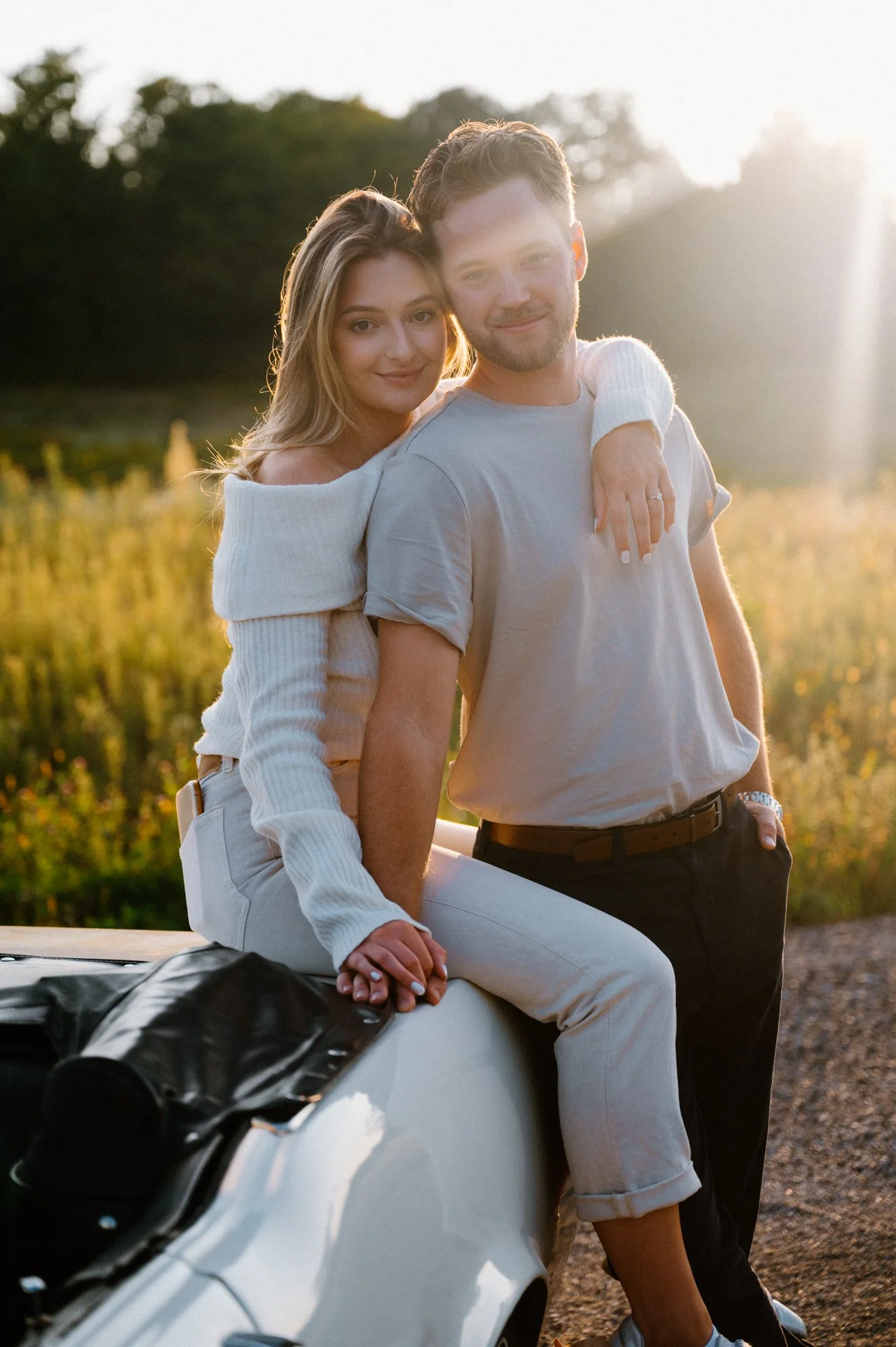Modern engagement session featuring a couple posed on a vintage Mustang at sunset in Pontypool, Ontario