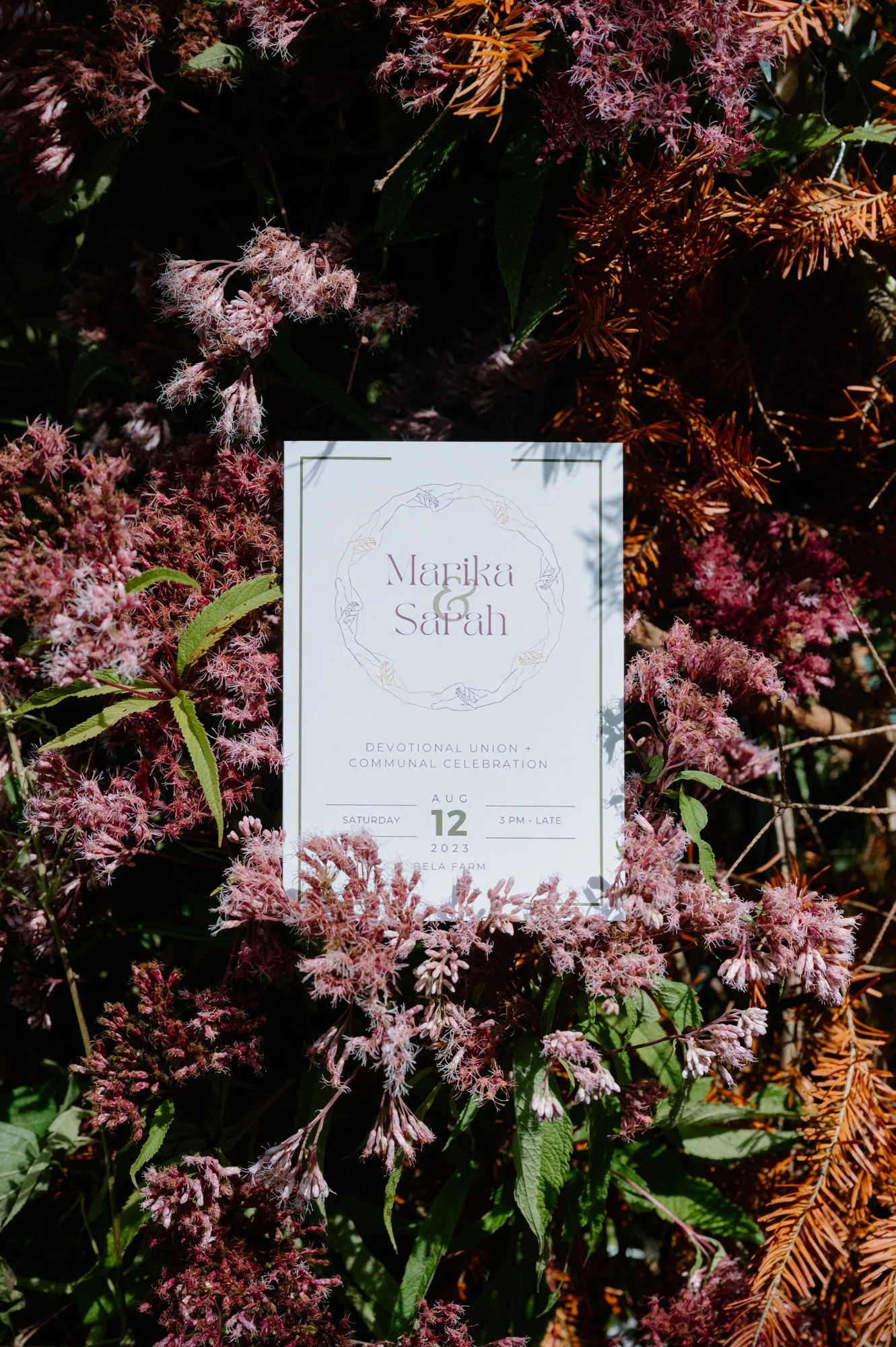 Detail photo of a wedding invitation resting on flowers at a rustic farm wedding near Orangeville, Ontario