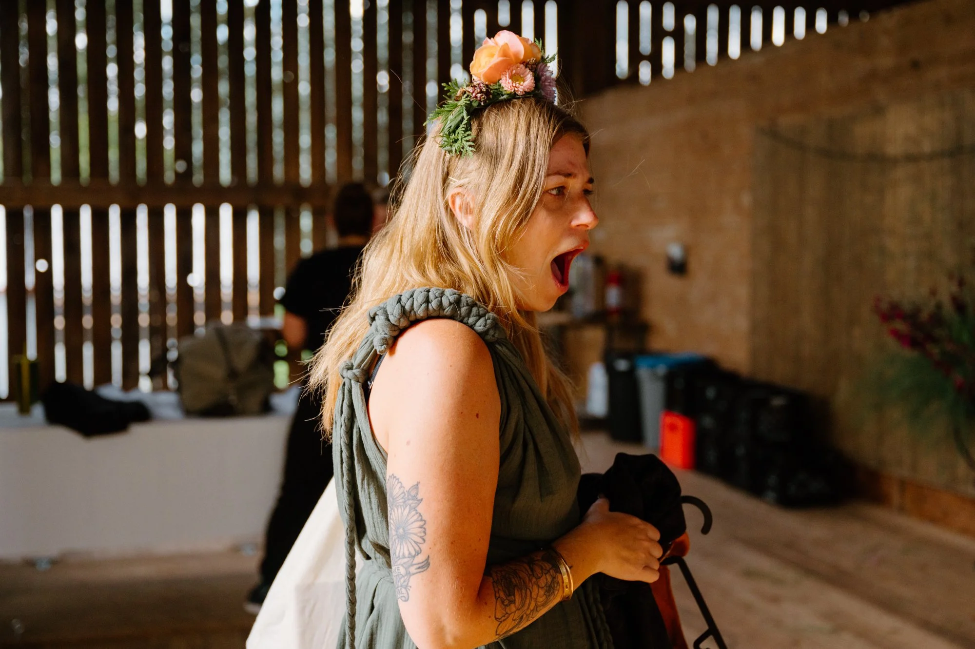 Candid photo of a bride genuinely surprised and emotional seeing the decorated barn at her farm wedding near Orangeville