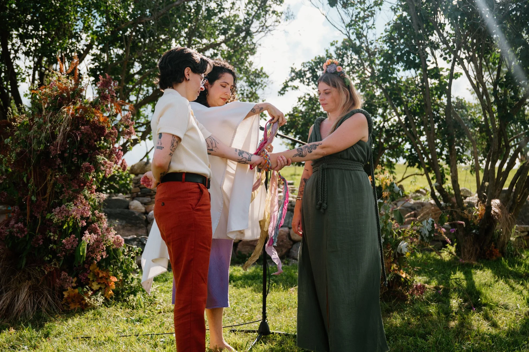 Documentary photo of a handfasting ritual during an outdoor farm wedding ceremony near Orangeville, Ontario